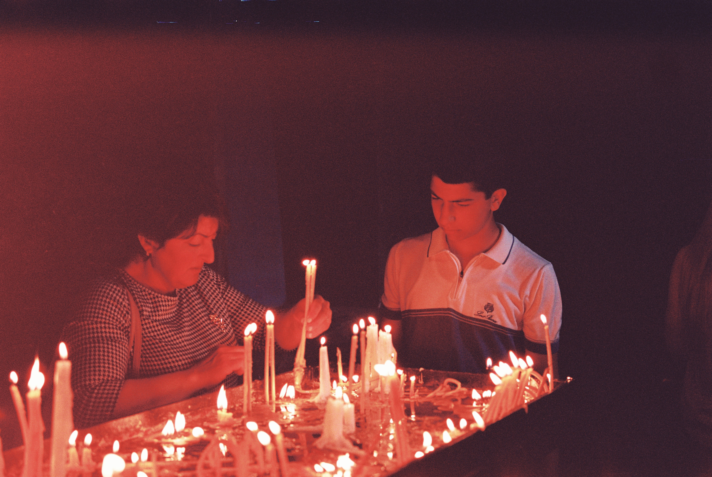 Two Armenians plant candles in Khor Virab. Karmir Film 160.
