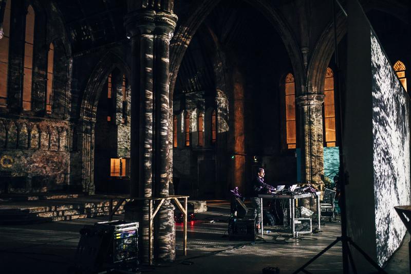 Max Cooper performing live inside Carlisle Memorial Church, surrounded by gothic architecture and immersive projections.