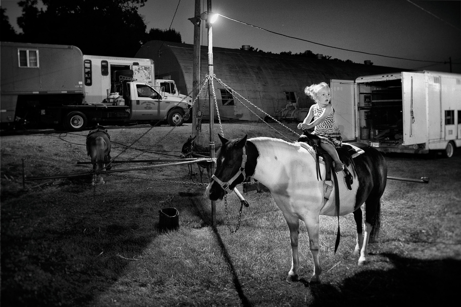 Child on a pony outside the tent in Brooklyn, Iowa.
