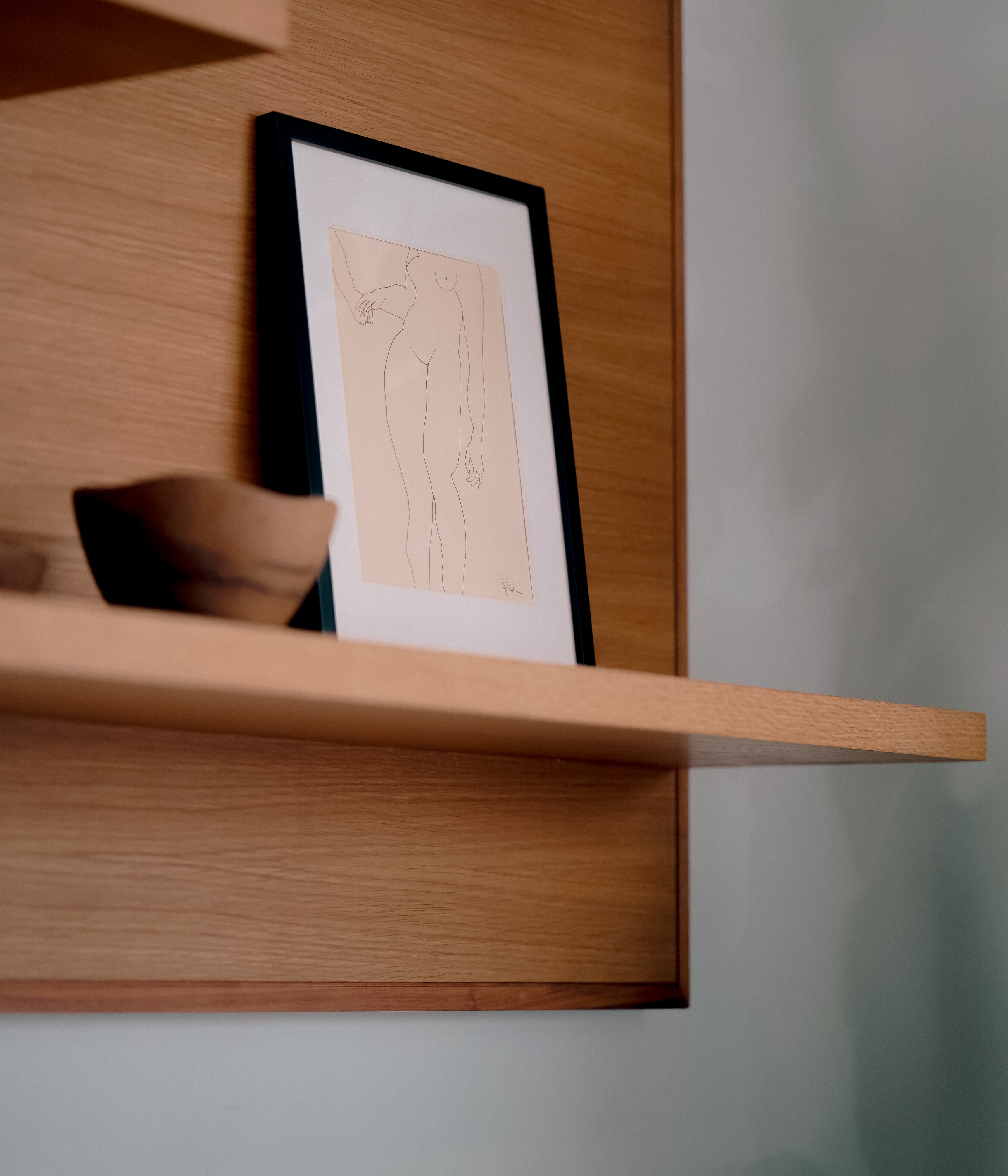 A wall shelf installation holds a fine art print.