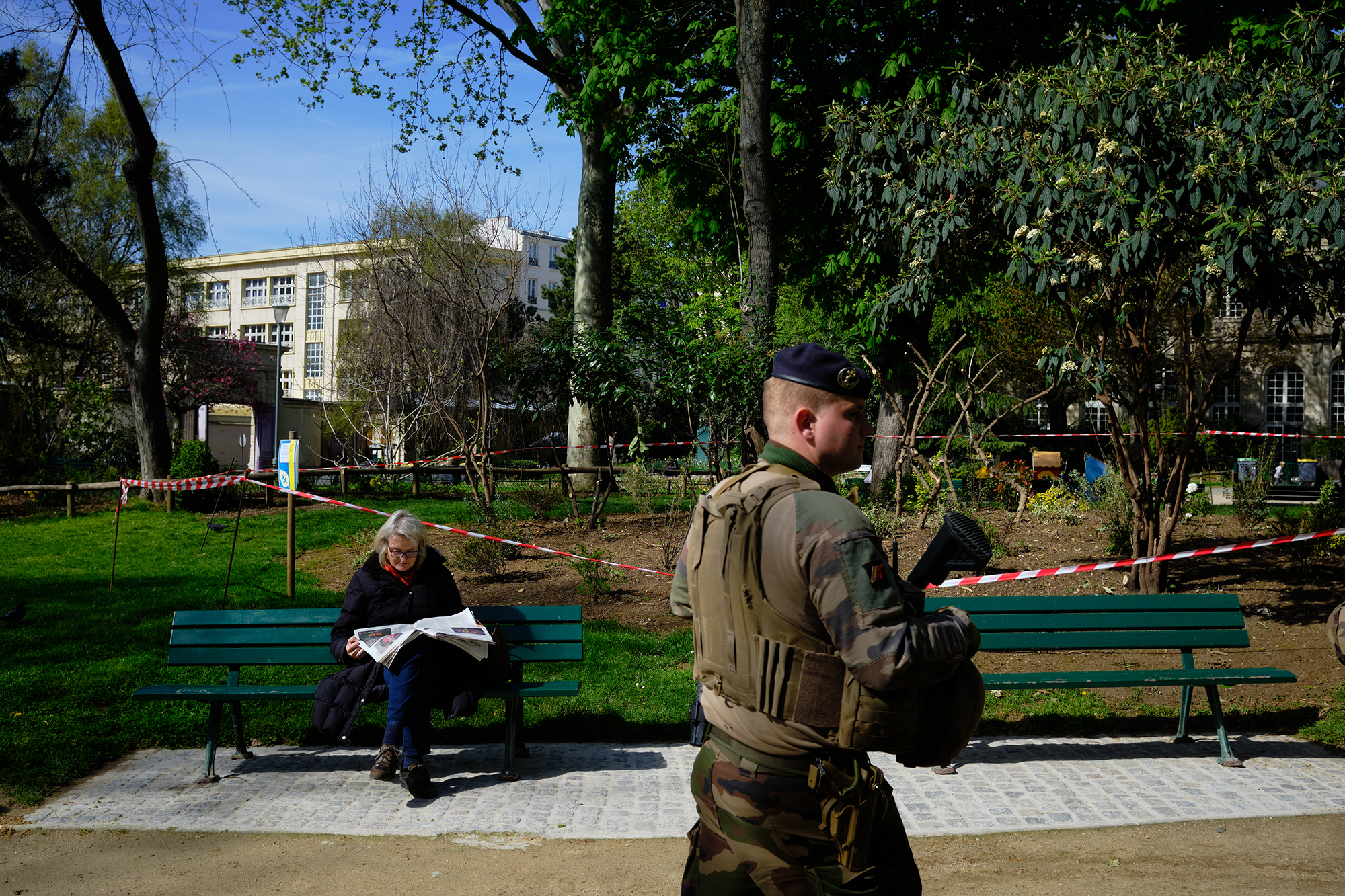 Philippe-Sarfati-reportage-photography-photographer-street-documentary-photojournalism-photojournalist-paris-french-presidential-elections-first-turn-vote-public-park-reading-newspaper-woman-military-man-walking-forbidden-access-security-band