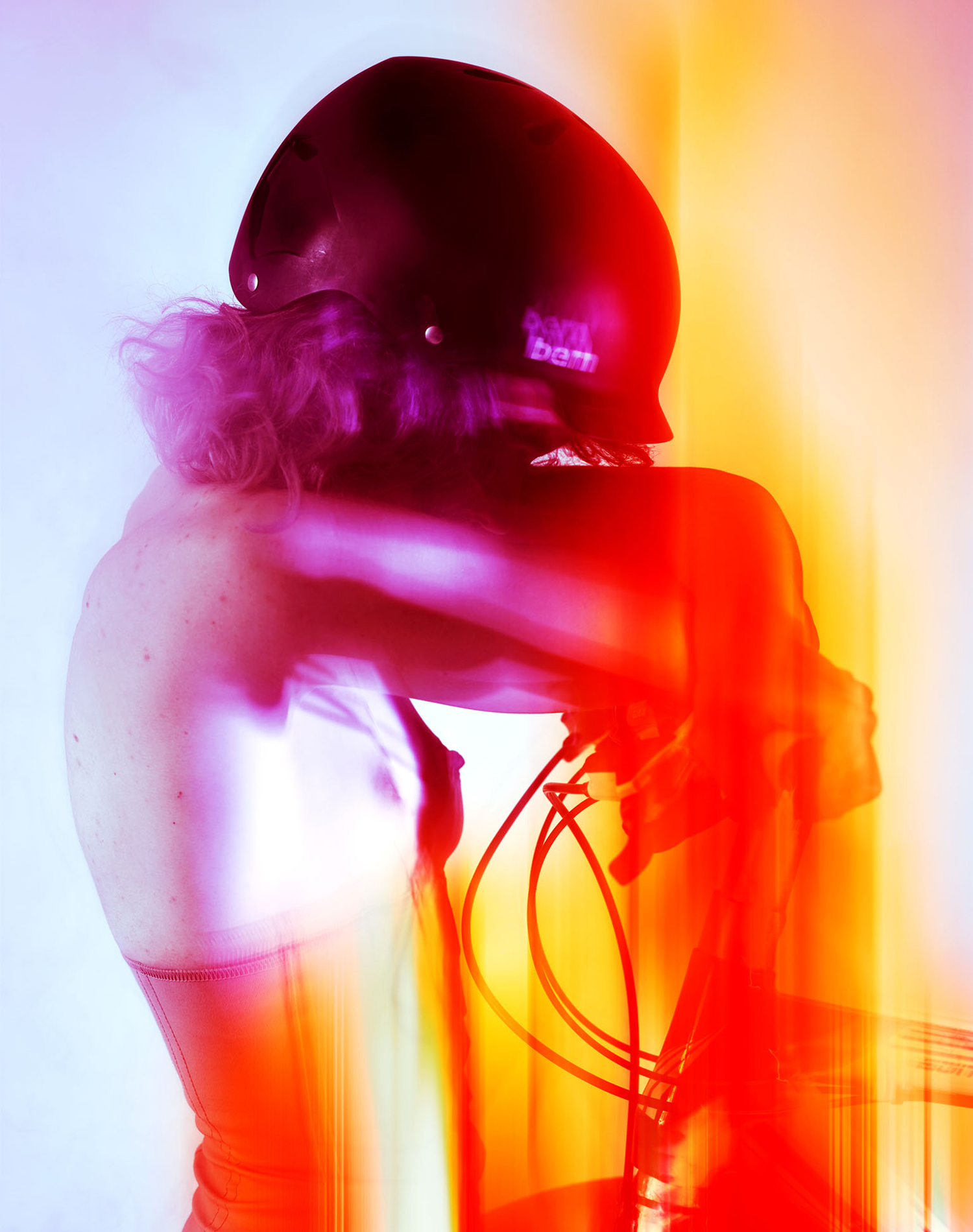 KMA photographer Daniel Schweizer shoots an abstract photo of a woman in a helmet against a bright orange and pink background