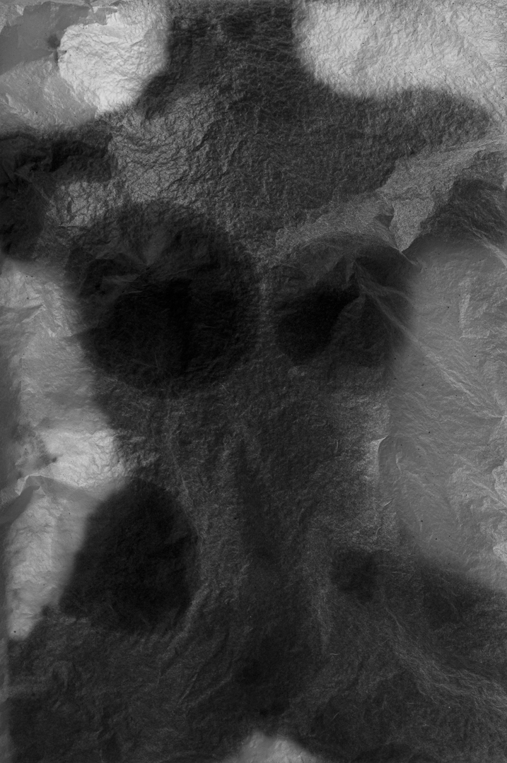 a female torso behind rice paper, oil from the figure is seeping into the rice paper