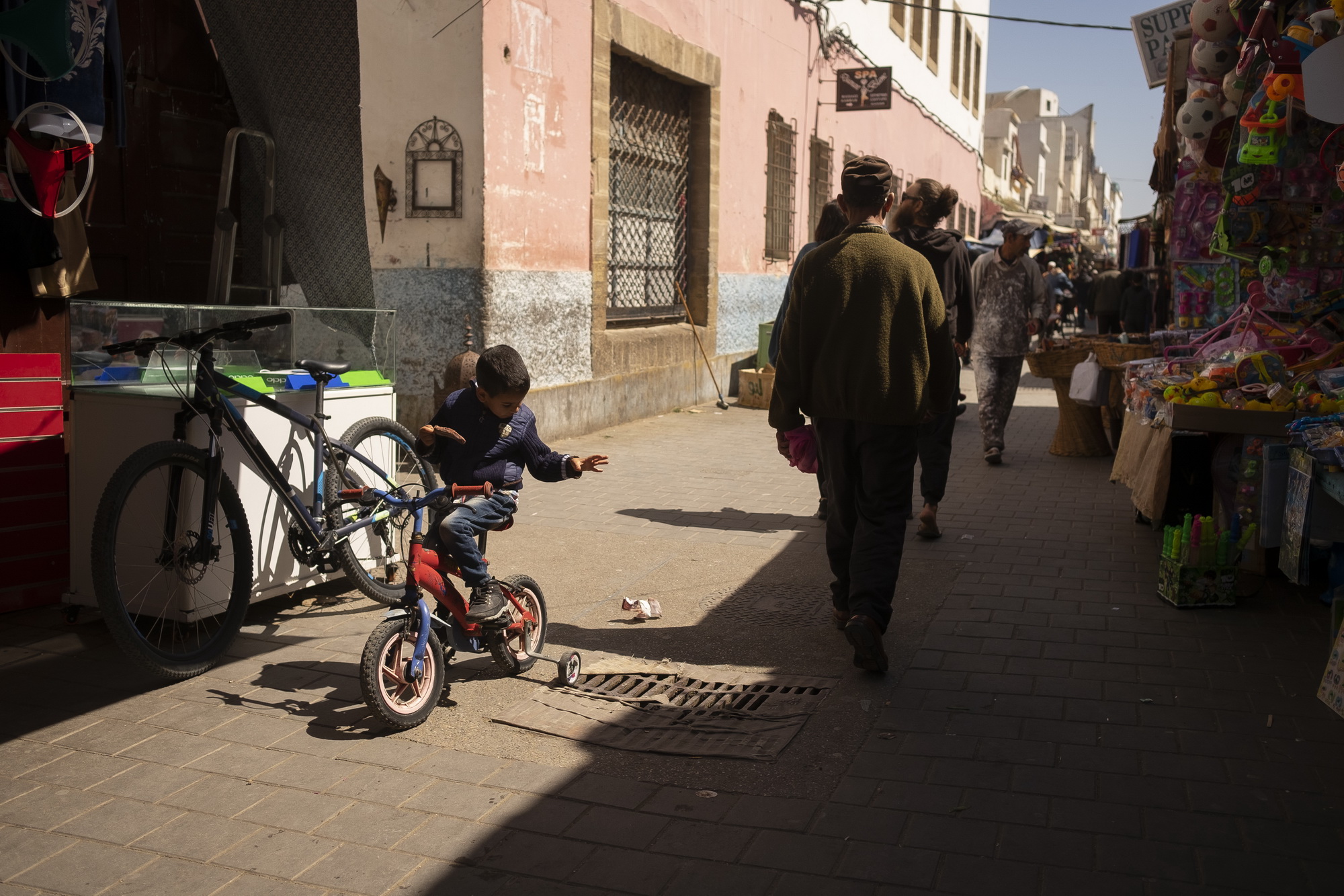 Boy drops his icecream wrapping, missing the gutter. 