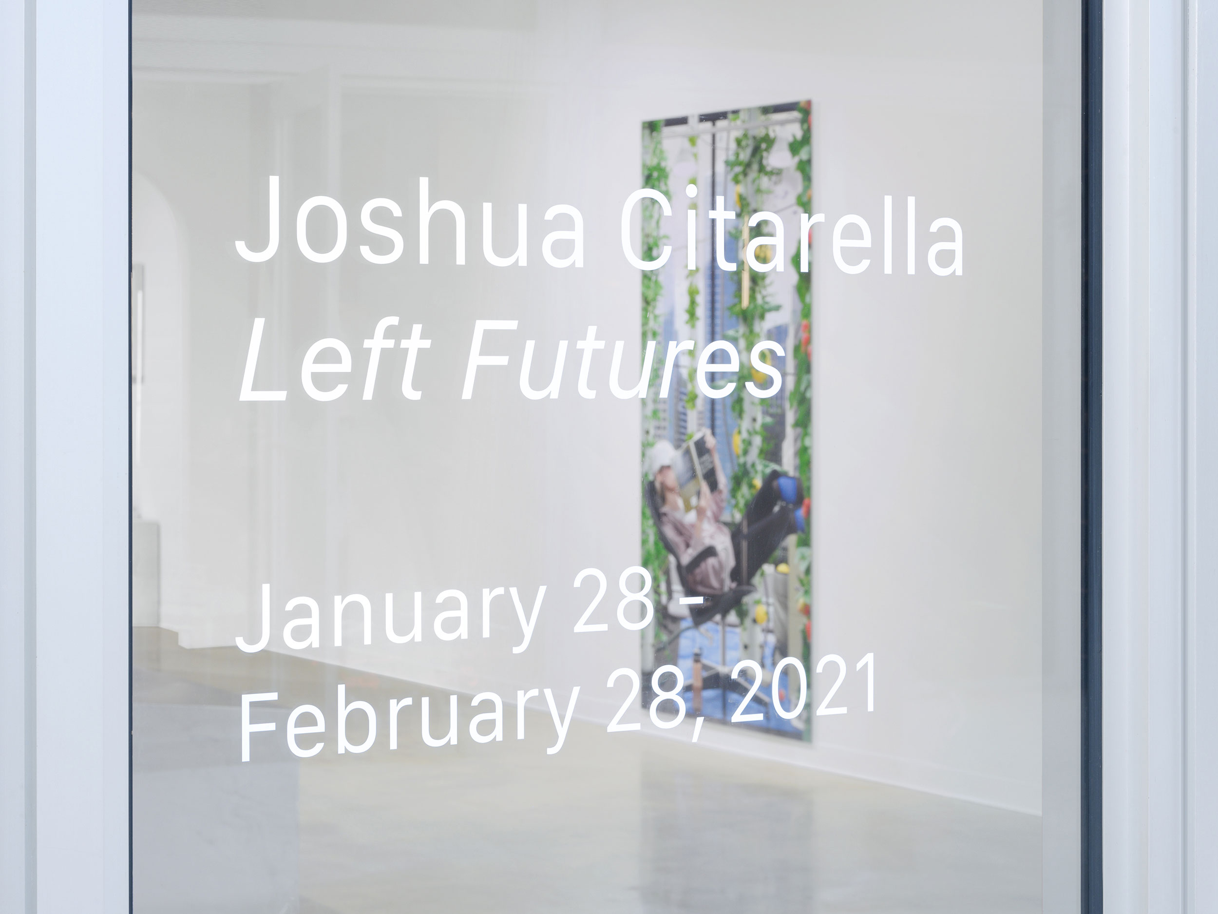 Installation view of “Left Futures” by Josh Citarella. 2021. Presented by Bas Fisher Invitational and Bridge Initiative. White text outside a window pane reads: “Joshua Citarella Left Futures January 28-Feburary 28, 2021”, Citarella’s Use-Value Urban Repurposing is visible beyond the glass.