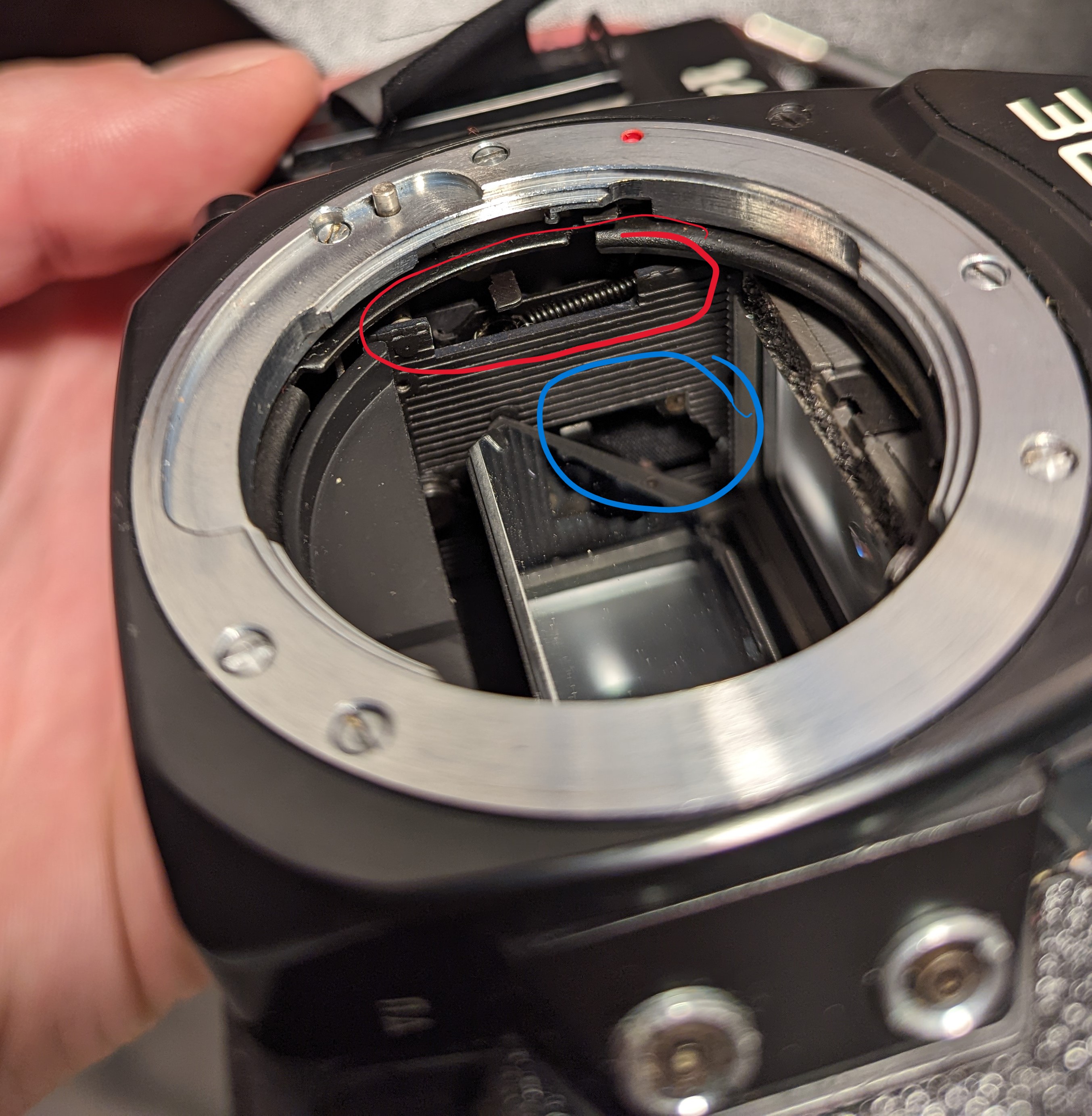 2. Mirror lowered in the mirror box. Red circle shows another part of the mechanism in the blue circle.