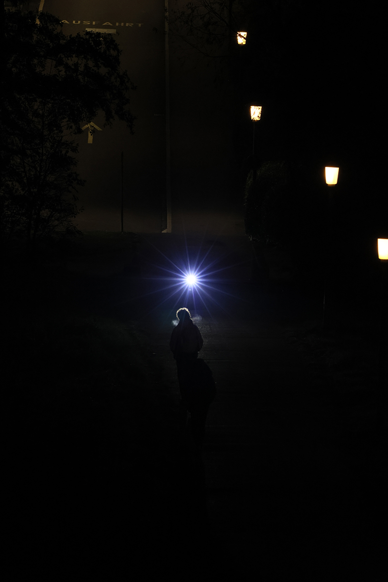 Im kalten Atem, vom Velo angestrahlt, tr&auml;gt sie ihr Gep&auml;ck heim &ndash; ein stilles Ende dieser Wege-Geschichte.