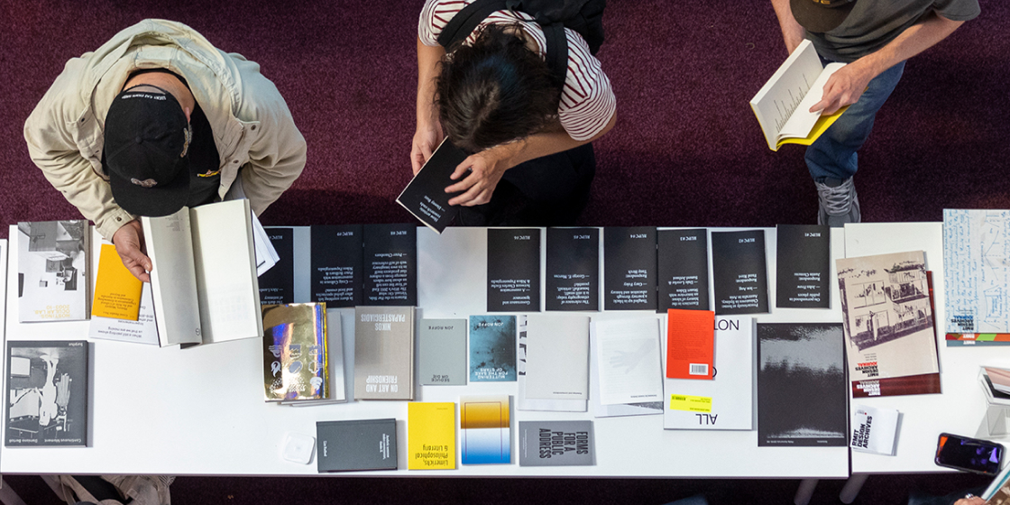 A goup of people were choosing books on a table.
