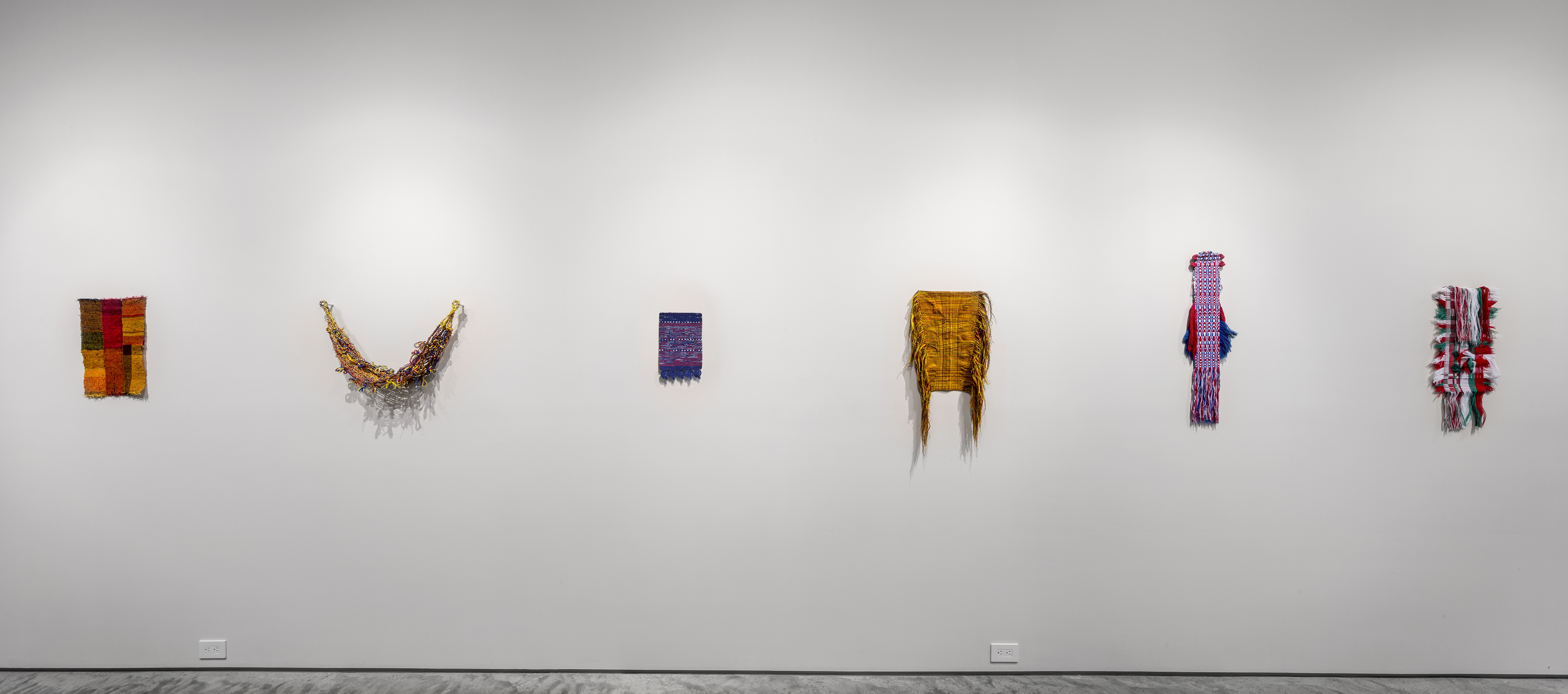 Sanne Vaassen, FLAGS series. From left to right: Woven by Miriam Hartwig, 2018, rewoven flag, Germany, 17.5" x 11.5." Woven by Erestina Pushaina, 2018, rewoven flag, Colombia, 41" x 7." Woven by Sara Lindsay, 2018, rewoven flag, Australia, 12" x 8." Woven by Lisa Decavel, 2016, rewoven flag, Belgium, 17 3/4" x 15." Woven by Jipke Lezwijn, 2016, rewoven flag, Netherlands, 37" x 12." Woven by Eszter Révész, 2018, rewoven flag, Hungary, 33"x10." 