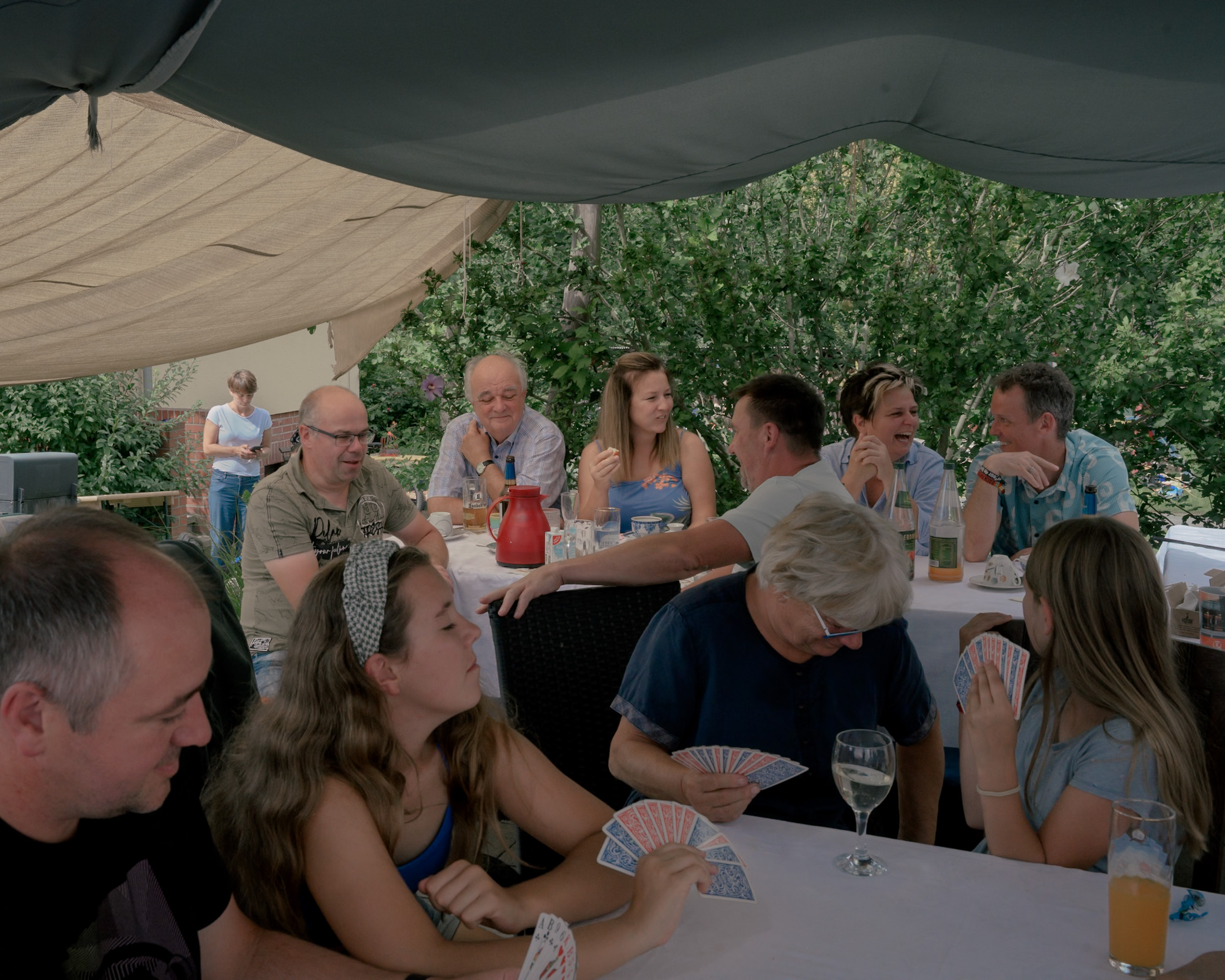 Dr. Gottfried Hanzl (left, behind red jug), 74, a general practitioner, during a family celebration in his garden in Oderwitz, Germany on August 11, 2024.