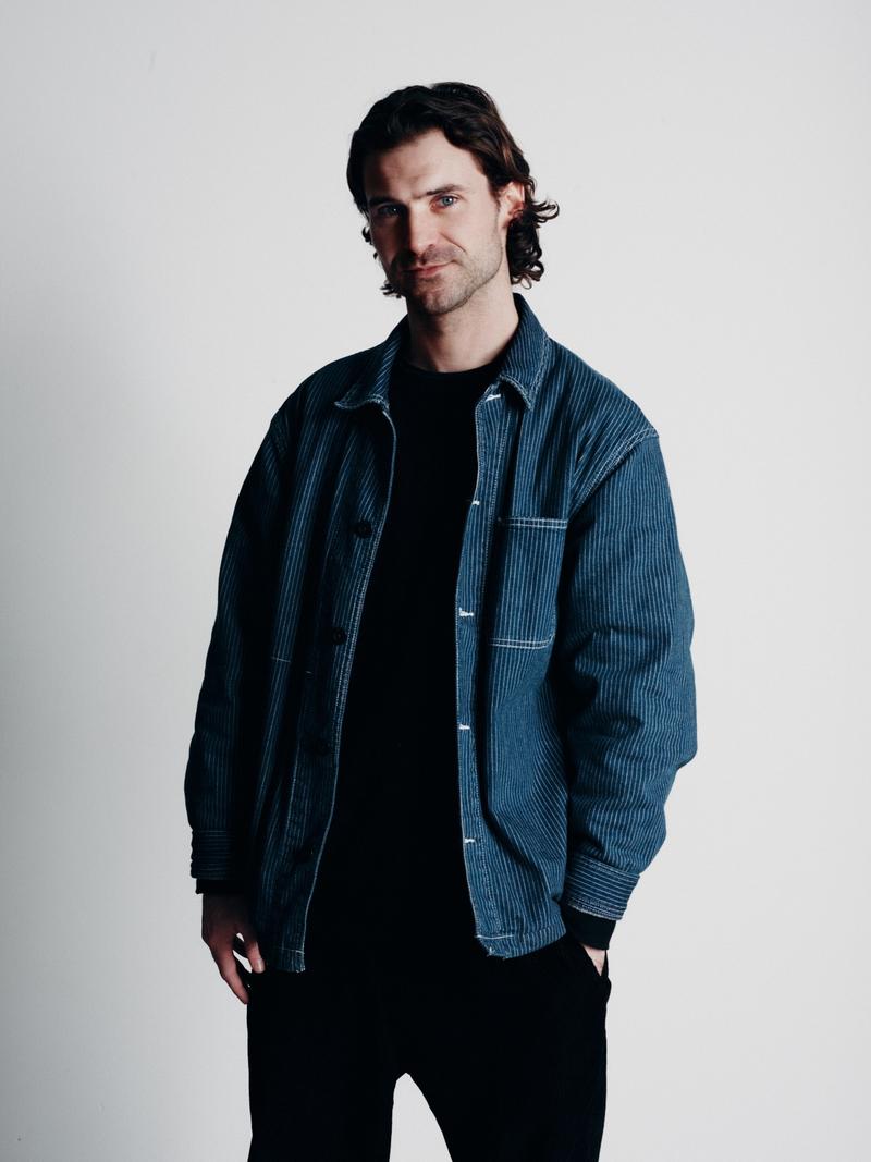 Emmett Costello, Senior Programmer & Curator at UP! Productions, wearing a blue corduroy jacket.