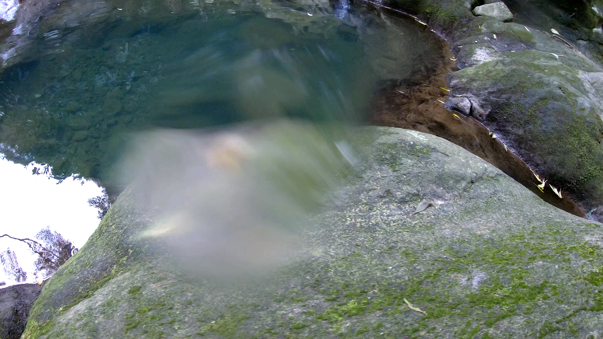 image from Zoë Mc Pherson's Music Video Lamella, directed by Alessandra Leone and picturing a 360 POV distorted view of river landscape and rocks