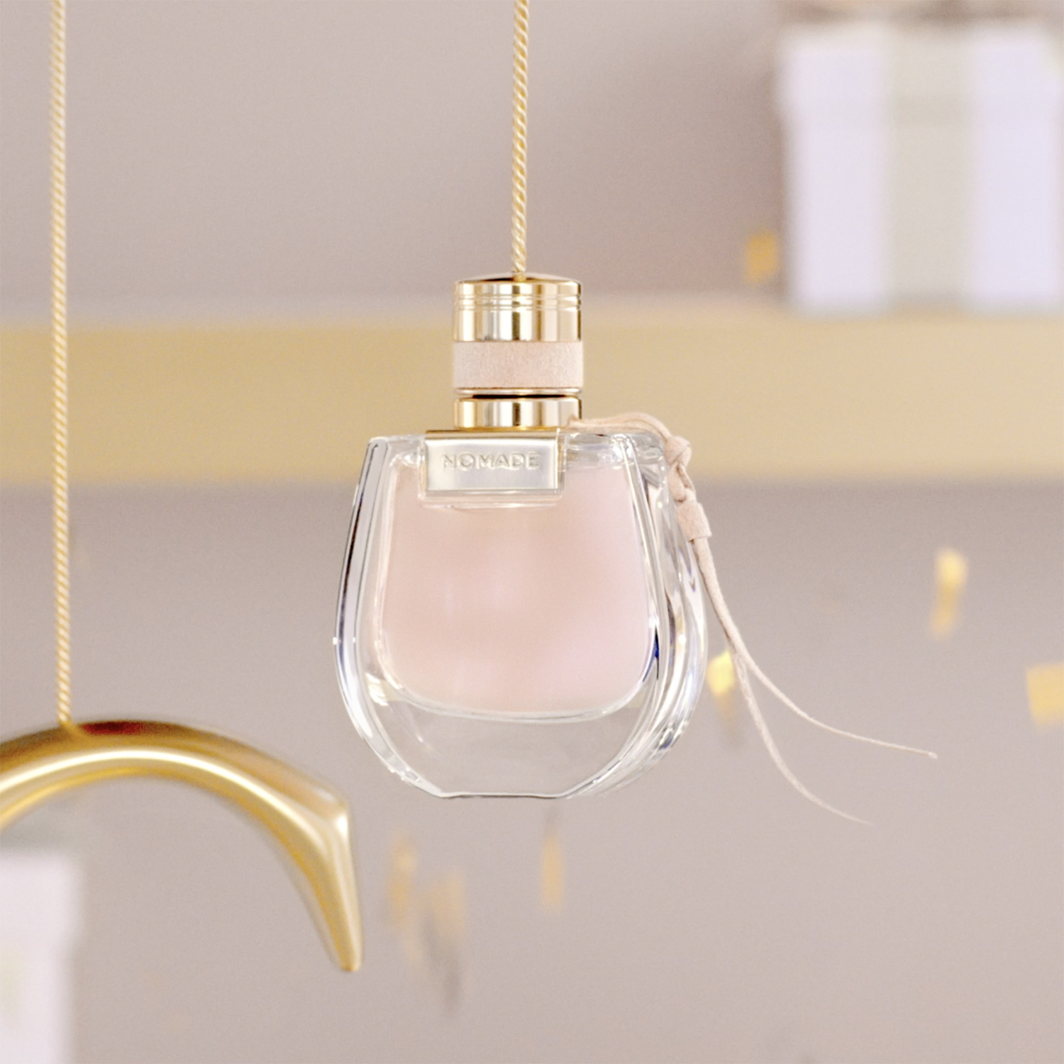 KMA photographer Vincent Gapaillard photographs a rose gold Chloe perfume bottle hanging from a string