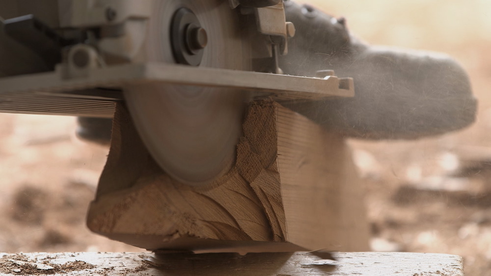 Detail of an assistant cutting a cedar beam, 2016.