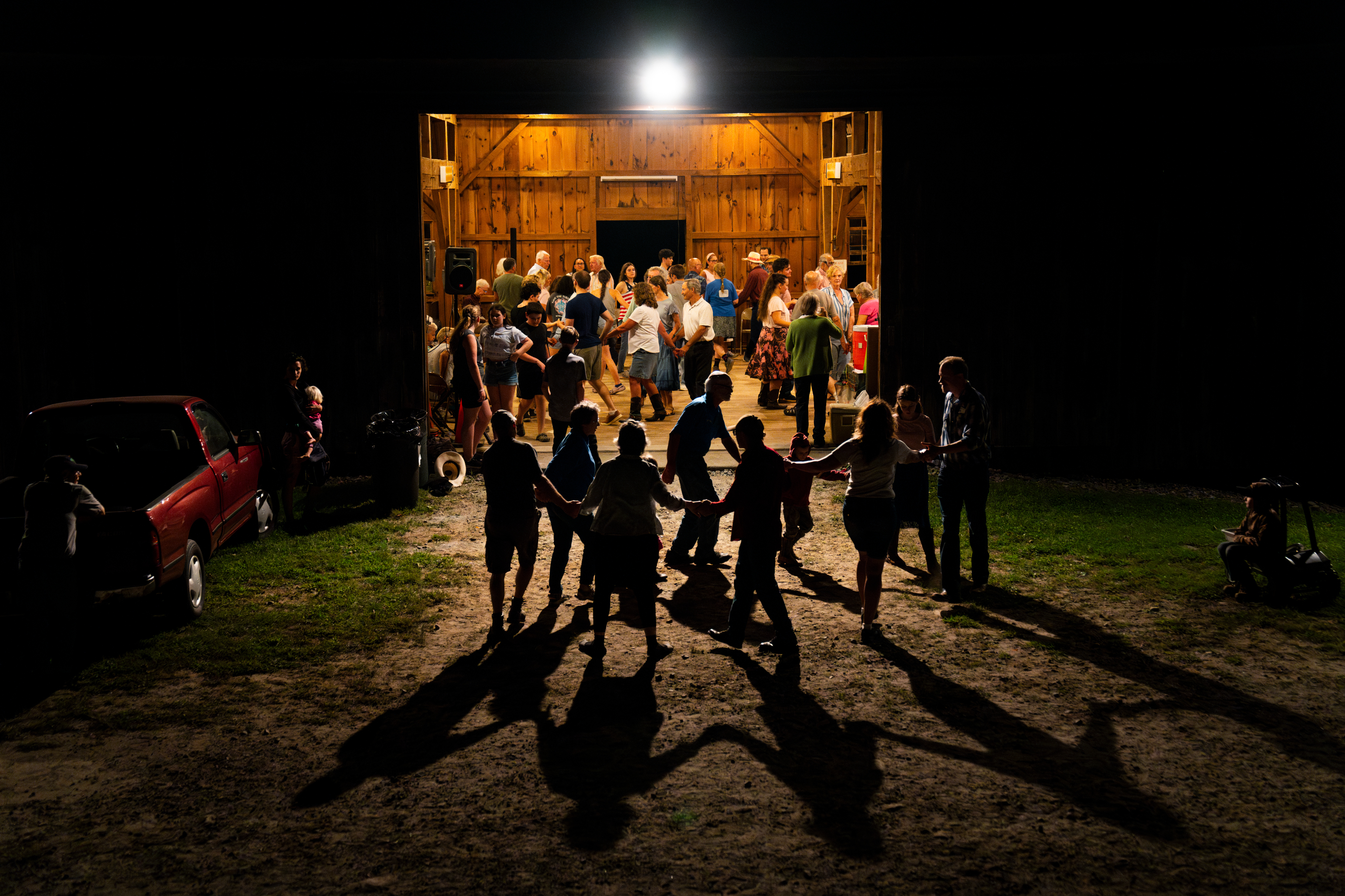 Guests square dance just outside the barn during a Blue Slope Country Museum barn dance in North Franklin, Conn. The farm and museum has been hosting weekly barn dances for 25 years. (Connecticut Public)