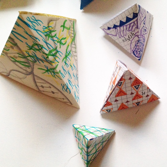 4 3D paper pyramids with illustrated patterns reminiscent of Science themes, DNA strands in multi coloured felt tip pens and pencils