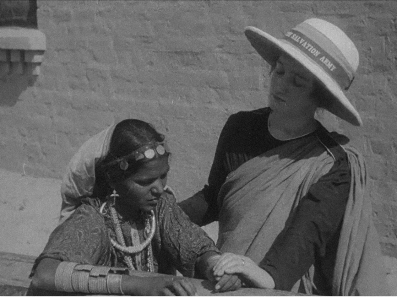 A Salvation Army officer is seen coercing an Indian woman to give up her traditional jewelry. Stills from a campaign film, Salvation Army Work in India, Burma, and Ceylon, 1925.
