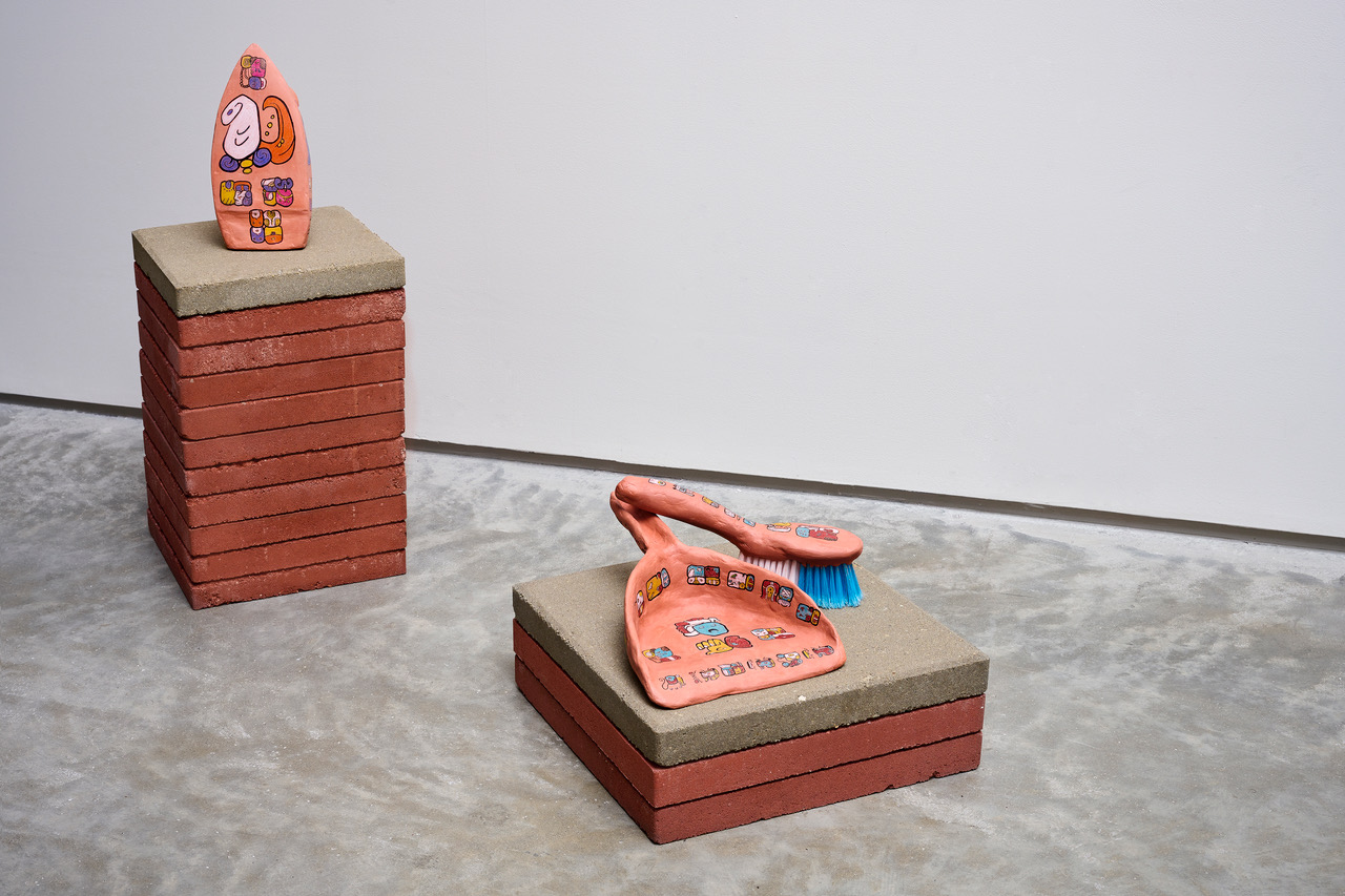 Jamie Martinez, "Me-Ya-AJ," 2023, ready-made iron covered in non-fired clay with Mayan glyphs, ready-made dustpan with brush covered with Mayan glyphs, Iron: 10 x 6 x 5 inches; Dustpan: 4 x 9 x 13 inches; Brush: 4.5 x 11 x 2.5 inches. Photo by Go Sugimoto.