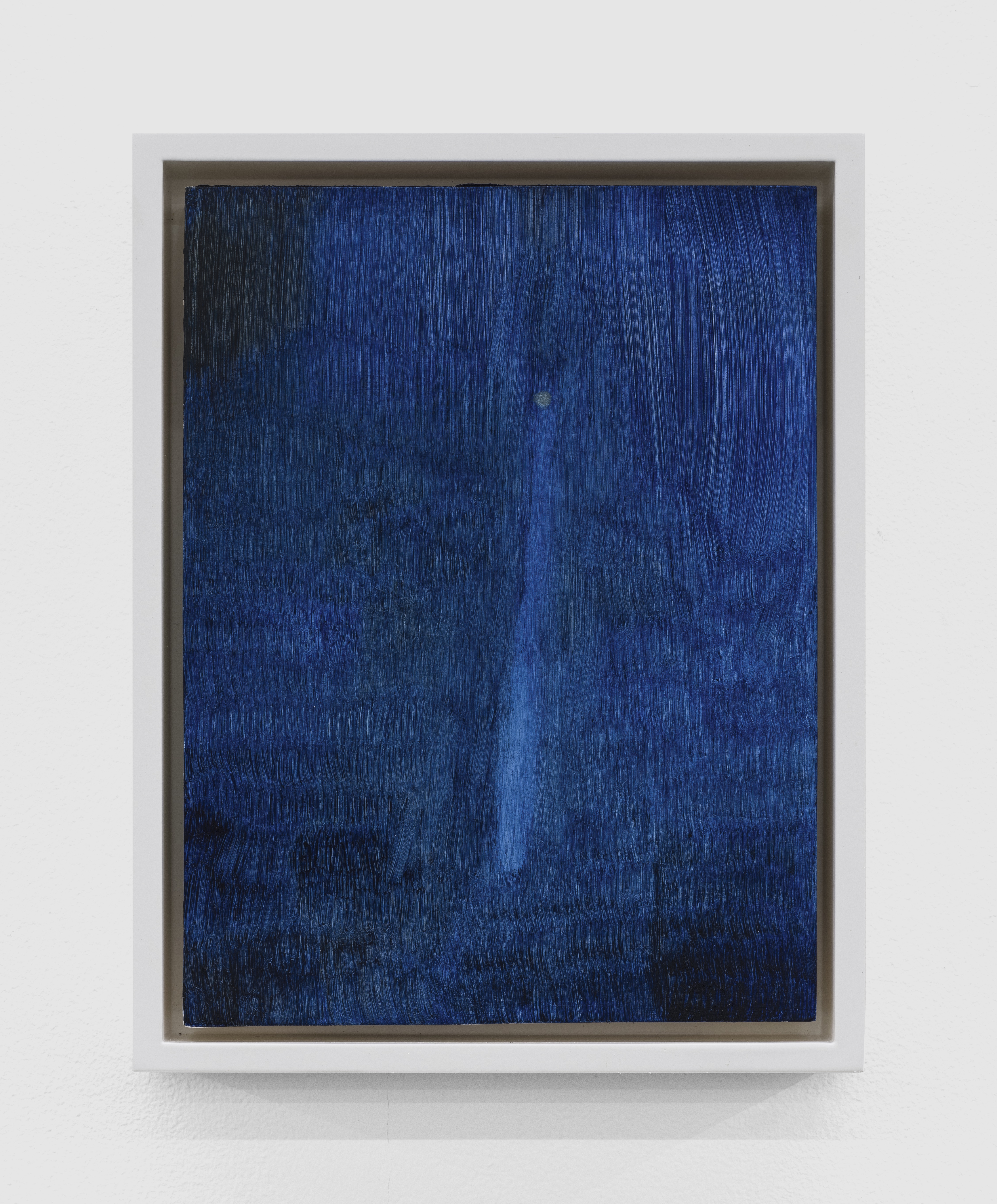 A moody, abstract, deep blue painting that gives the feeling of looking at the moon under a thick fog, or that of a small flashlight in an impossibly large cave.