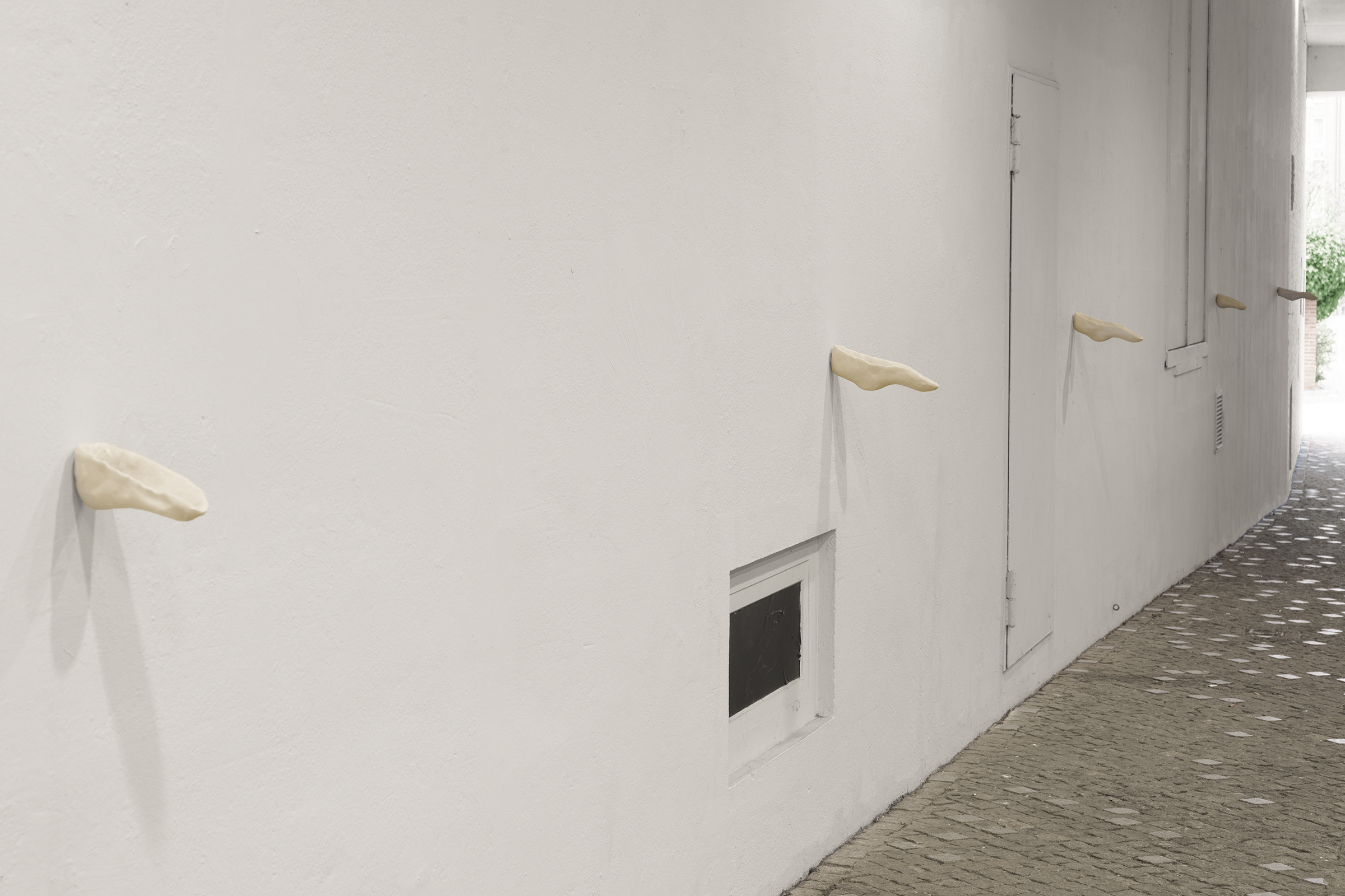 Bystanders (Public Ashtray), 2026. Acrylic One resin, air-dry porcelain, cigarettes and rubbish added by the passerby (outdoor installation). Various dimensions.