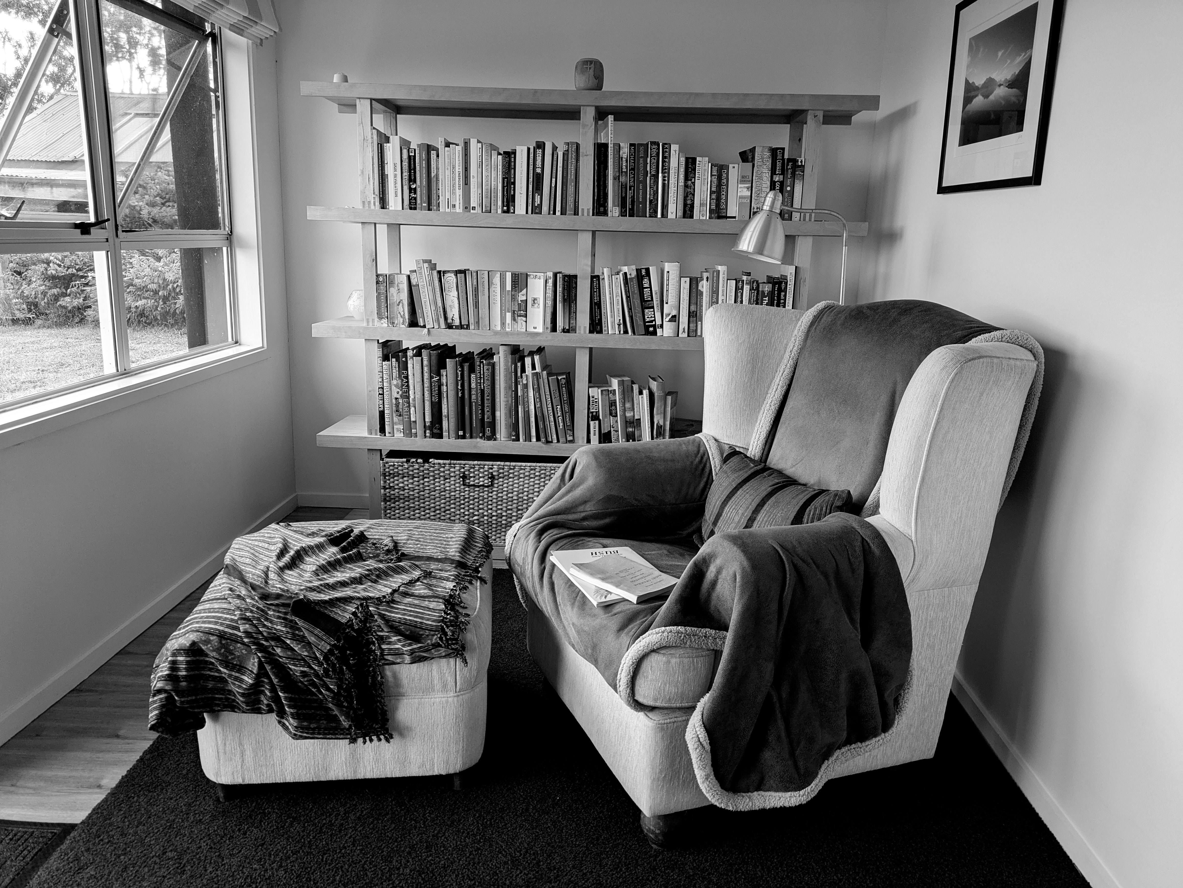A woman finds a place to read in Aotearoa. (Rangihaeata, New Zealand)