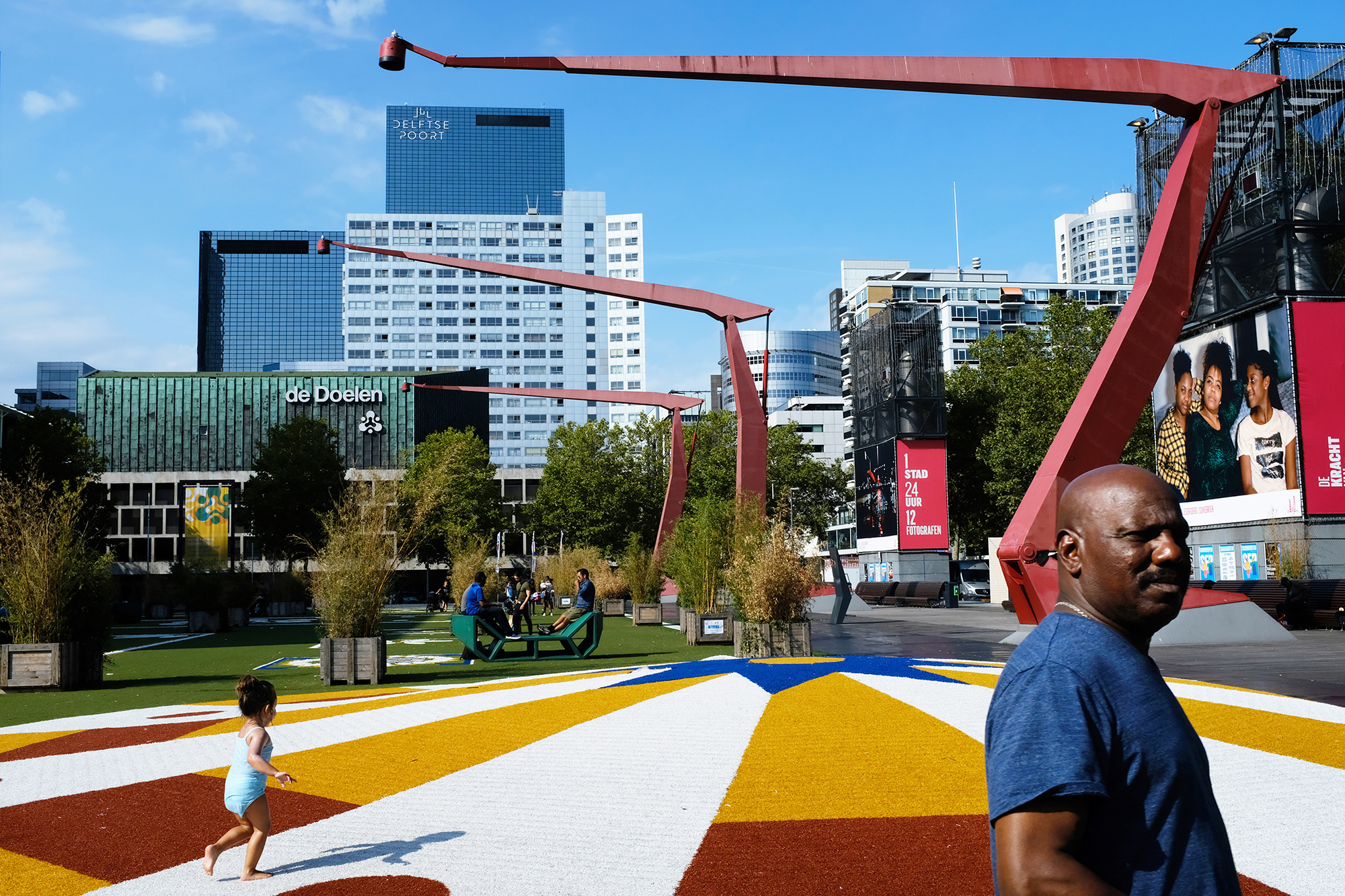 Philippe Sarfati-architecture photography-photographer-photography-street-documentary-architecture-rotterdam-netherlands-west8-schouwburgplein-red cranes-bright colors-yellow-people-black man-child running-de doelen