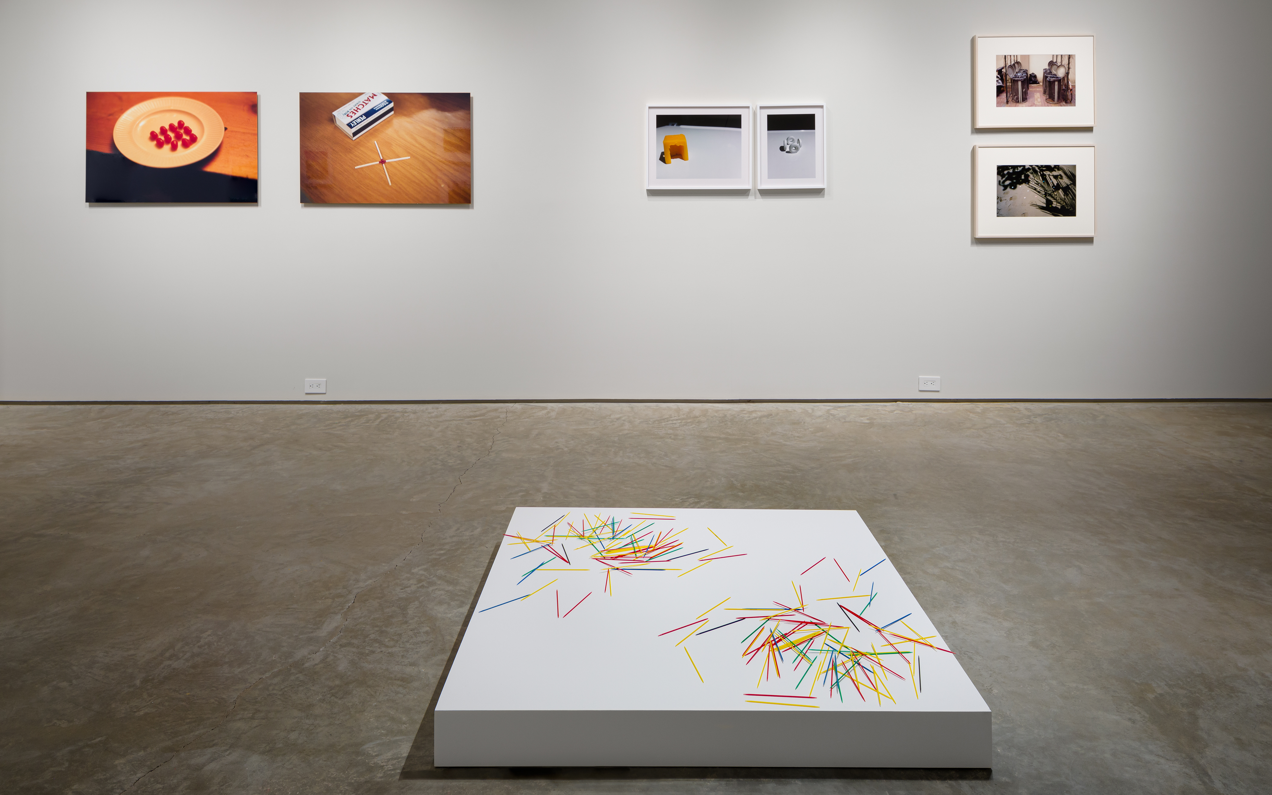 From left: Rivane Neuenschwander, "Conversation 8," 2002, C-print on aluminum, 26 x 40 inches. Rivane Neuenschwander, "Conversation 5," 2002, C-print on aluminum, 26 x 40 inches. Tom Friedman, "Untitled (pick up sticks), 1990, Pick up sticks scattered on one side of plinth and reproduced on the other, dimensions variable. Nina Katchadourian, "Cheese Hut," 2012 ("Seat Assignment" project, 2010 and ongoing), C-print, Edition of 8 + 2AP; edition X/8 19 x 24 inches. Nina Katchadourian, "Sun Tunnels," 2012 ("Seat Assignment" project, 2010 and ongoing), C-print, Edition of 8 + 2AP; edition X/8, 19 x 15 1/4 inches. Gabriel Orozco, "Trashcan Opera," 1995, Dye destruction print, 12 1/2 x 18 3/4 inches. Gabriel Orozco, "Star Caps," 2001, C-print, 16 x 20 inches.  