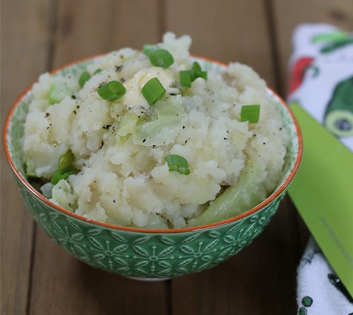 a close-up picture of a healthy serving of Irish colcannon in a teal bowl