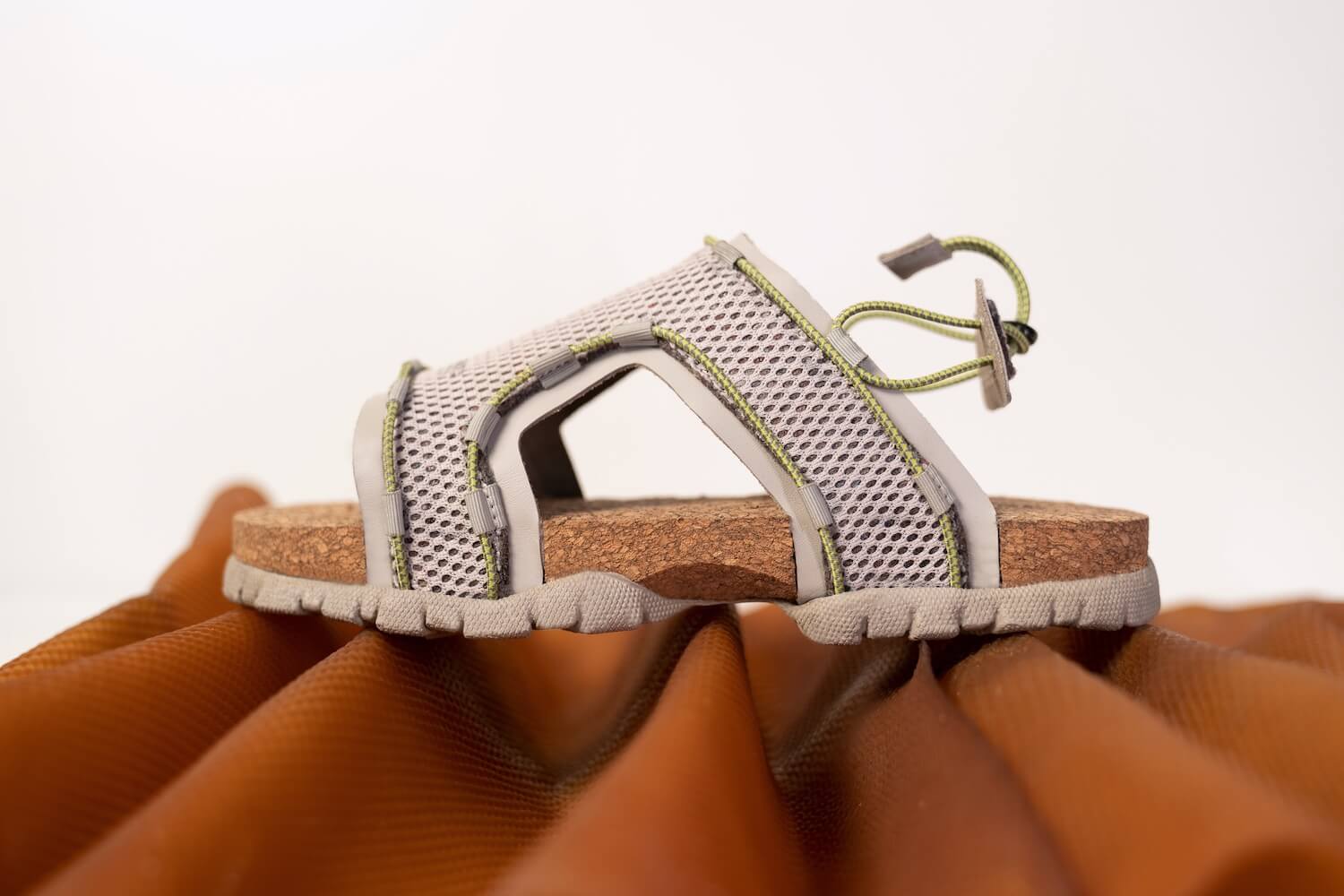 A sandal with grey white mesh and natural sole