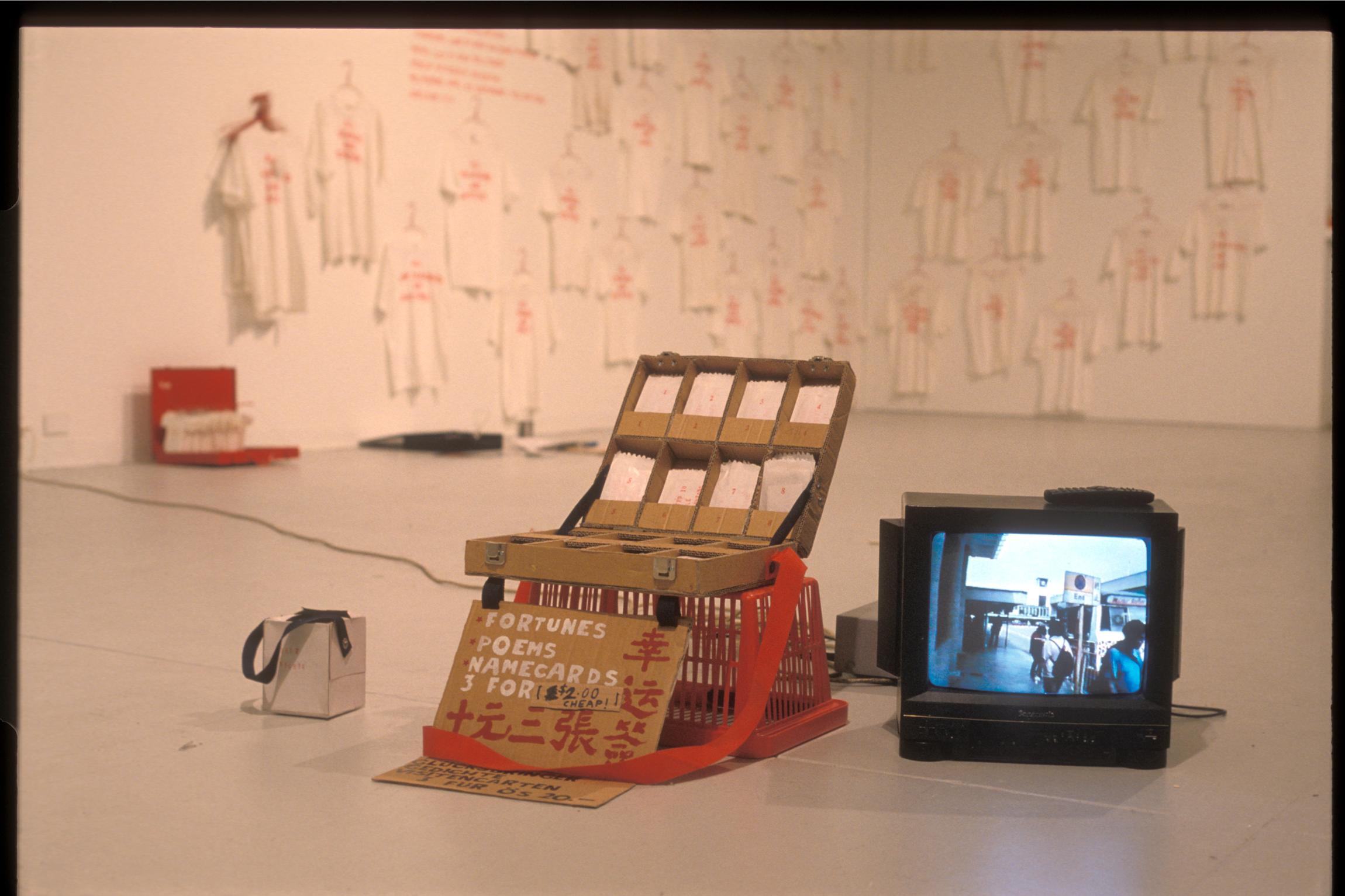 Lucas Ihlein, Will Work for Money, as part of ARX5 Artists Regional Exchange, exhibited at Hong Kong University of Science and Technology, 1999; Sydney-Vienna, Akademie der Bilden Kunst, Vienna, 2000; STUFF Gallery London 2000; Bilateral, Experimental Art Foundation, Adelaide, 2002. Installed in background: Event for Touristic Sites