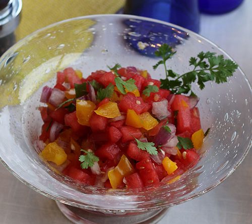 An up-close picture of colorful watermelon salsa in a clear bowl