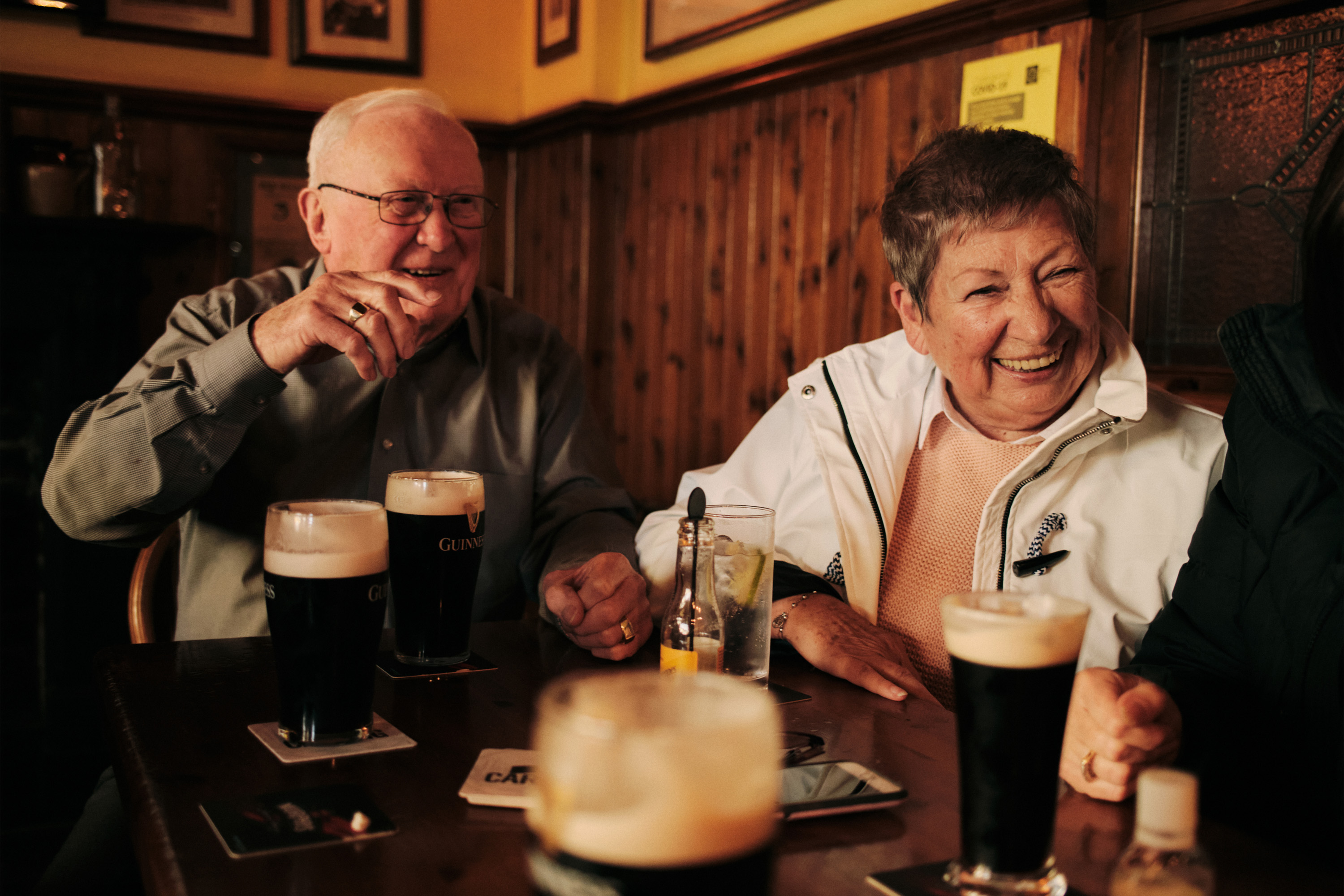 Grandparents enjoying Guinness in a cosy Irish pub, photographed by Dublin-based lifestyle, fashion, and advertising photographer Alex Sheridan, capturing authentic energy and real moments