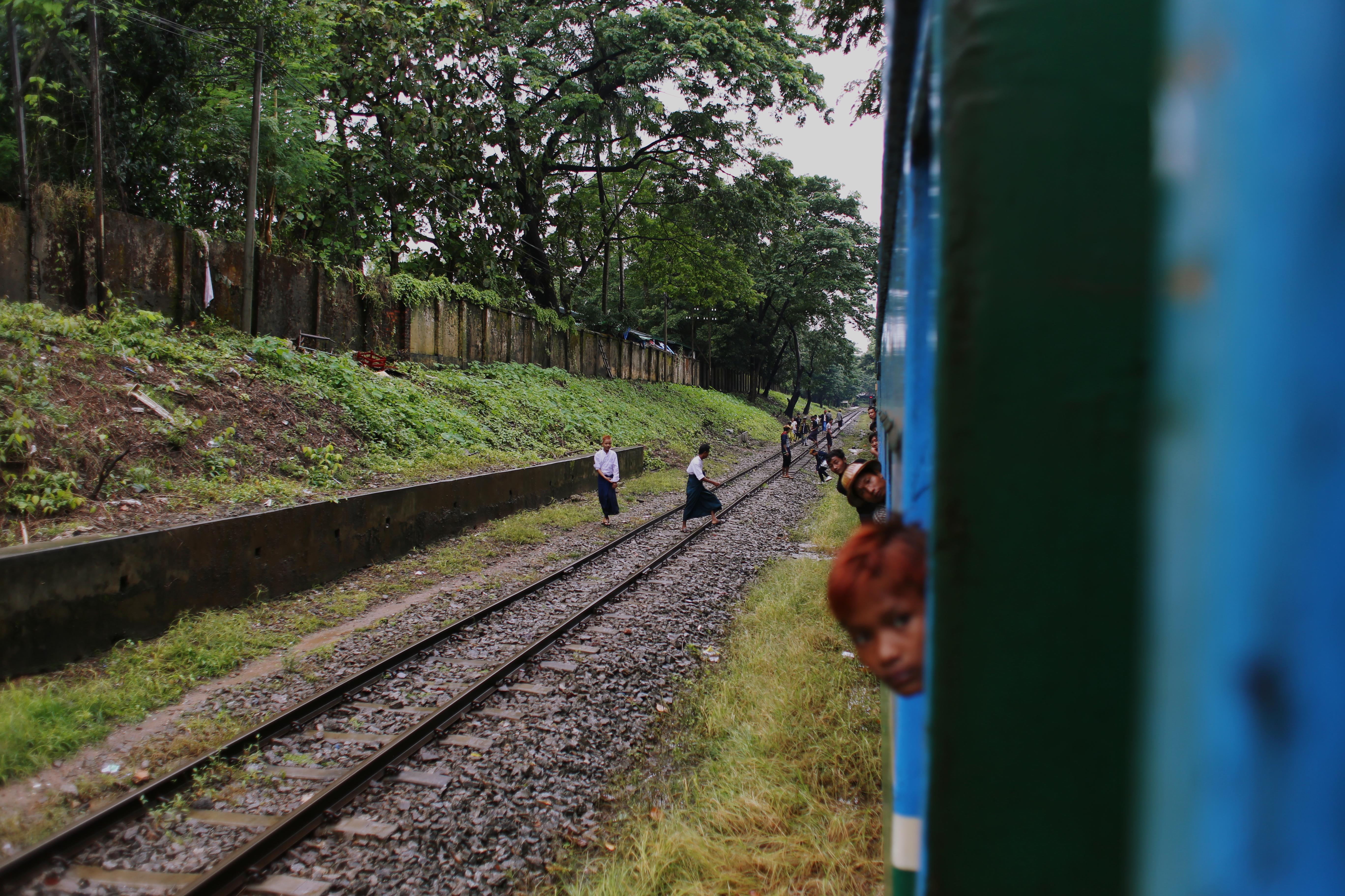 Bright blue and green paintwork snakes around the tracks, cracked from use and weather. If the train is moving slow enough to disembark between stations, passengers throw bags and packages from doors and leap from carriages before fading into the distance. The best way to gauge the cause of an unexpected stoppage is to stick your head out the window.