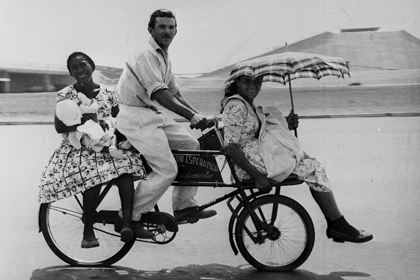 9: Duas mulheres, dois bebês e um homem em uma bicicleta no Eixo Monumental em Brasília, à altura do Teatro Nacional [two women, two babies and a man on a bicycle on the Eixo Monumental in Brasília, near the Teatro Nacional], 29 mar 1979 – 2 jul 1982