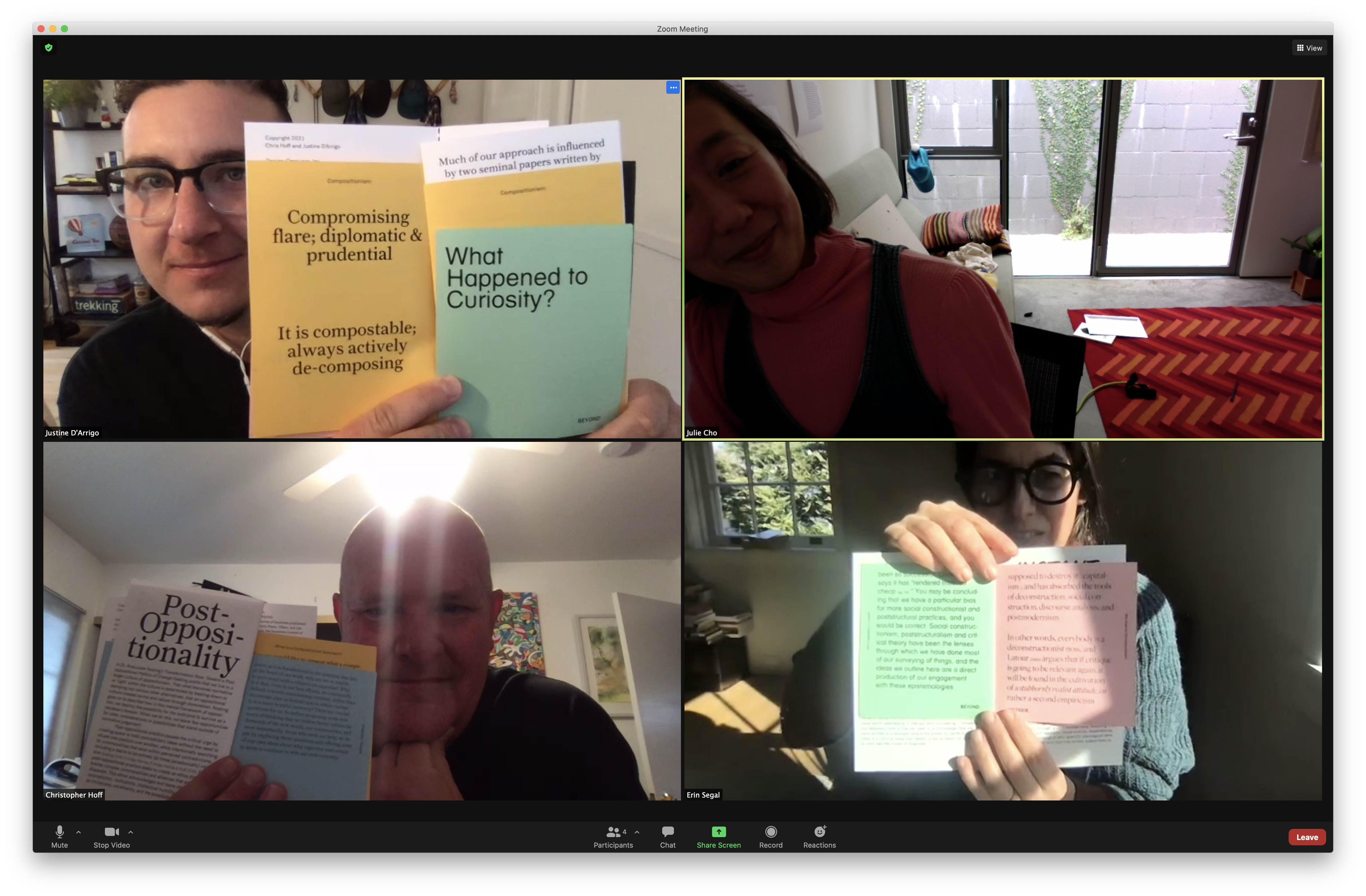 4 people on zoom holding up booklets