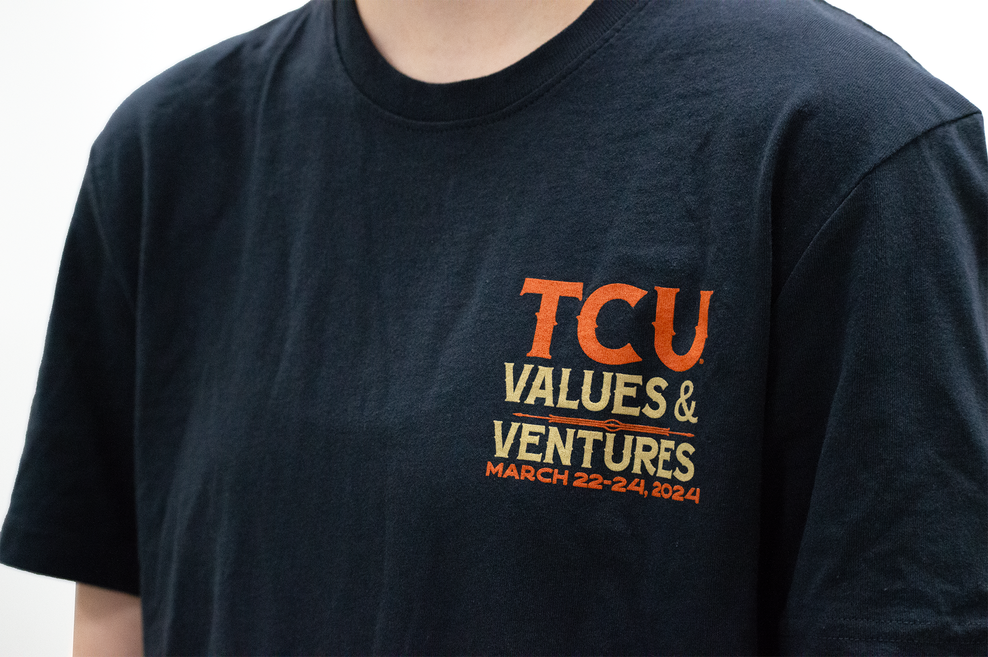 An up close front angled studio shot of a model wearing the printed TCU Values & Ventures T-Shirt.