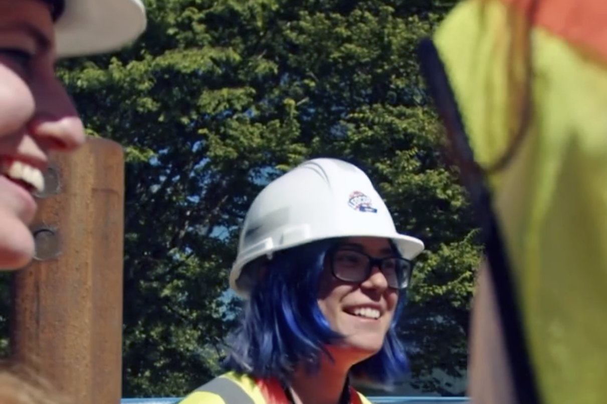 Two young women laughing wearing hard hats