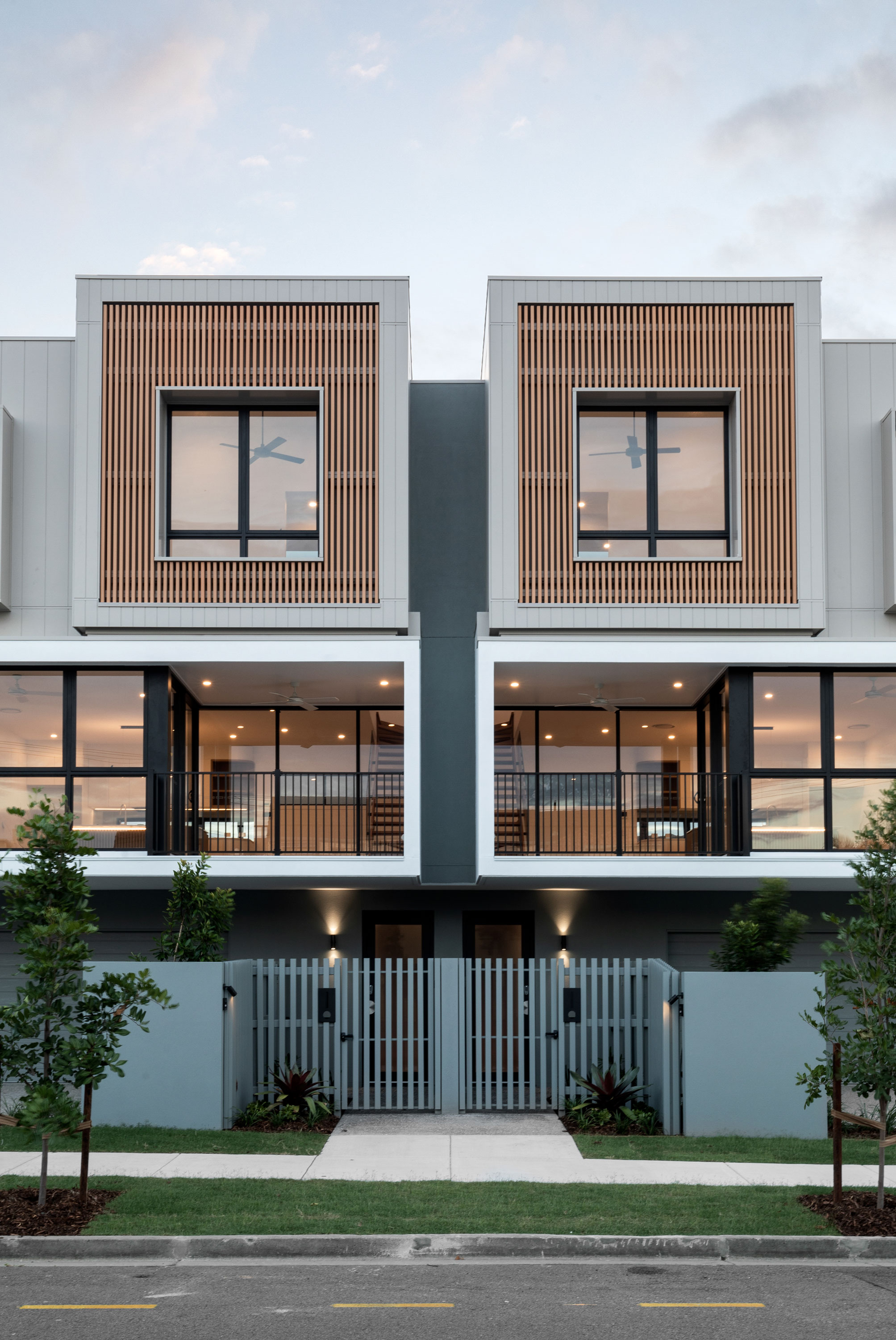 Modern townhouses with balconies and a fence, creating a stylish and secure living environment.