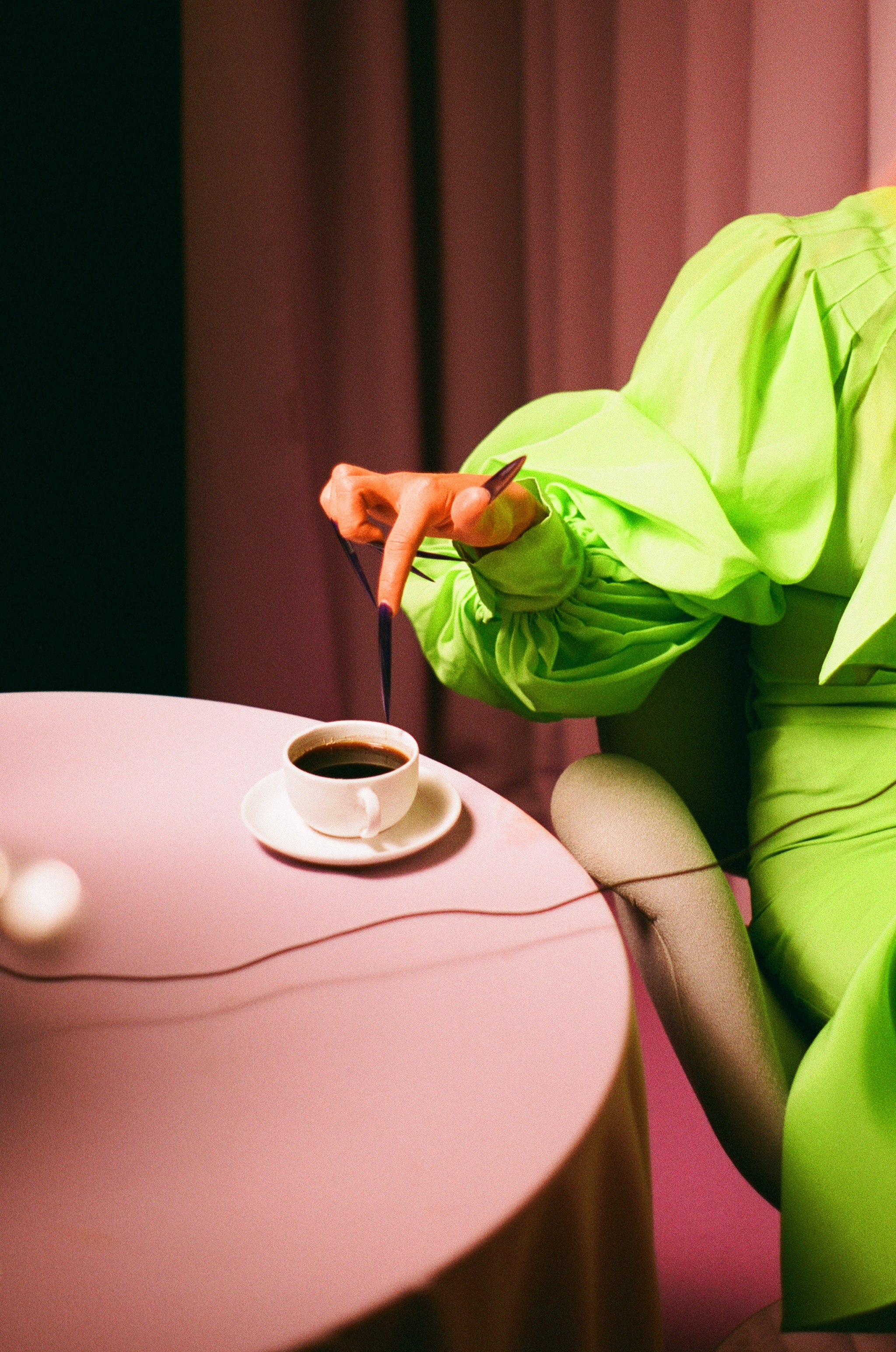 Woman with long nail stirring coffee