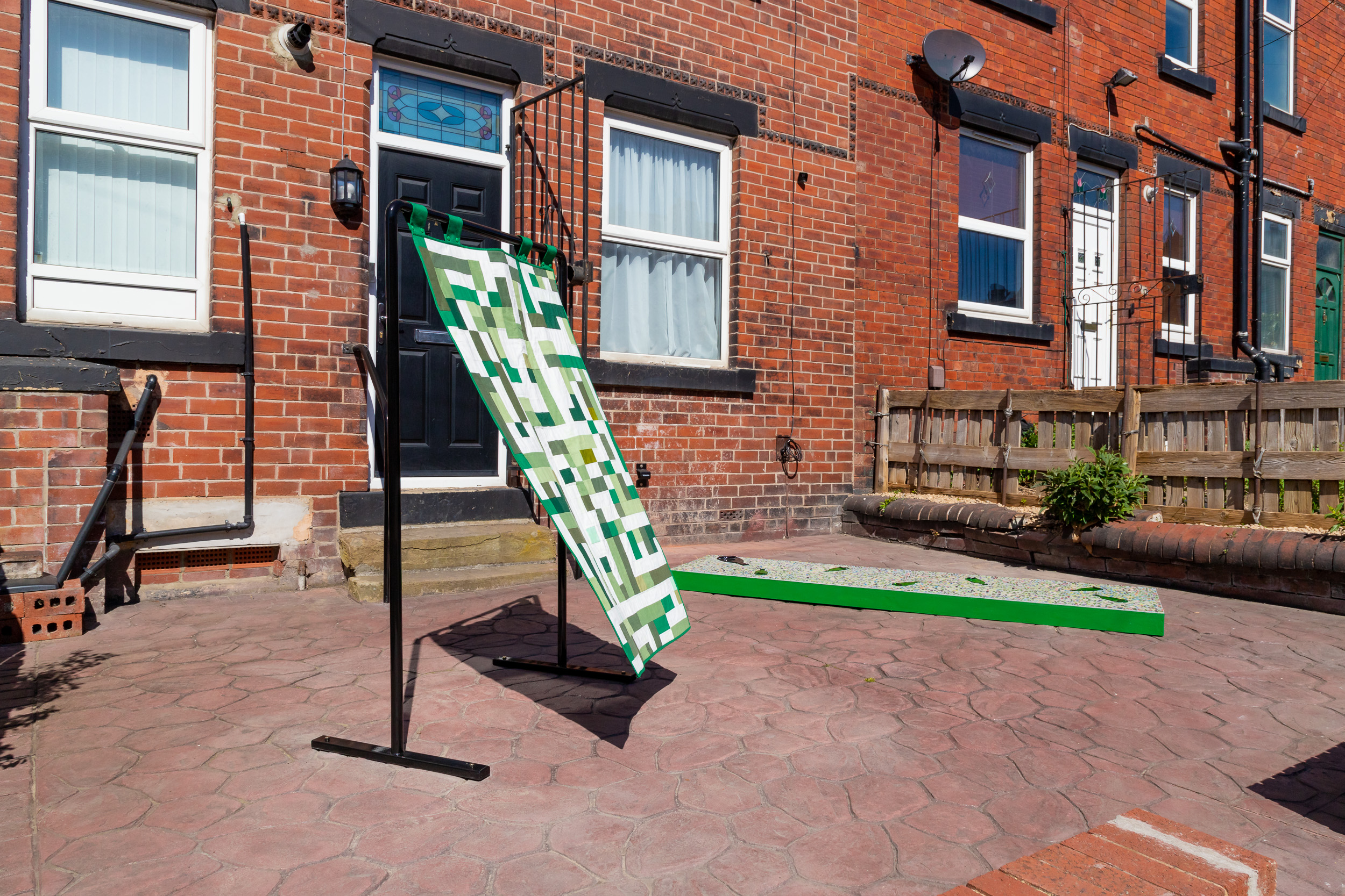 'Patchwork Maze' and 'Variegated' in front of a terraced house.