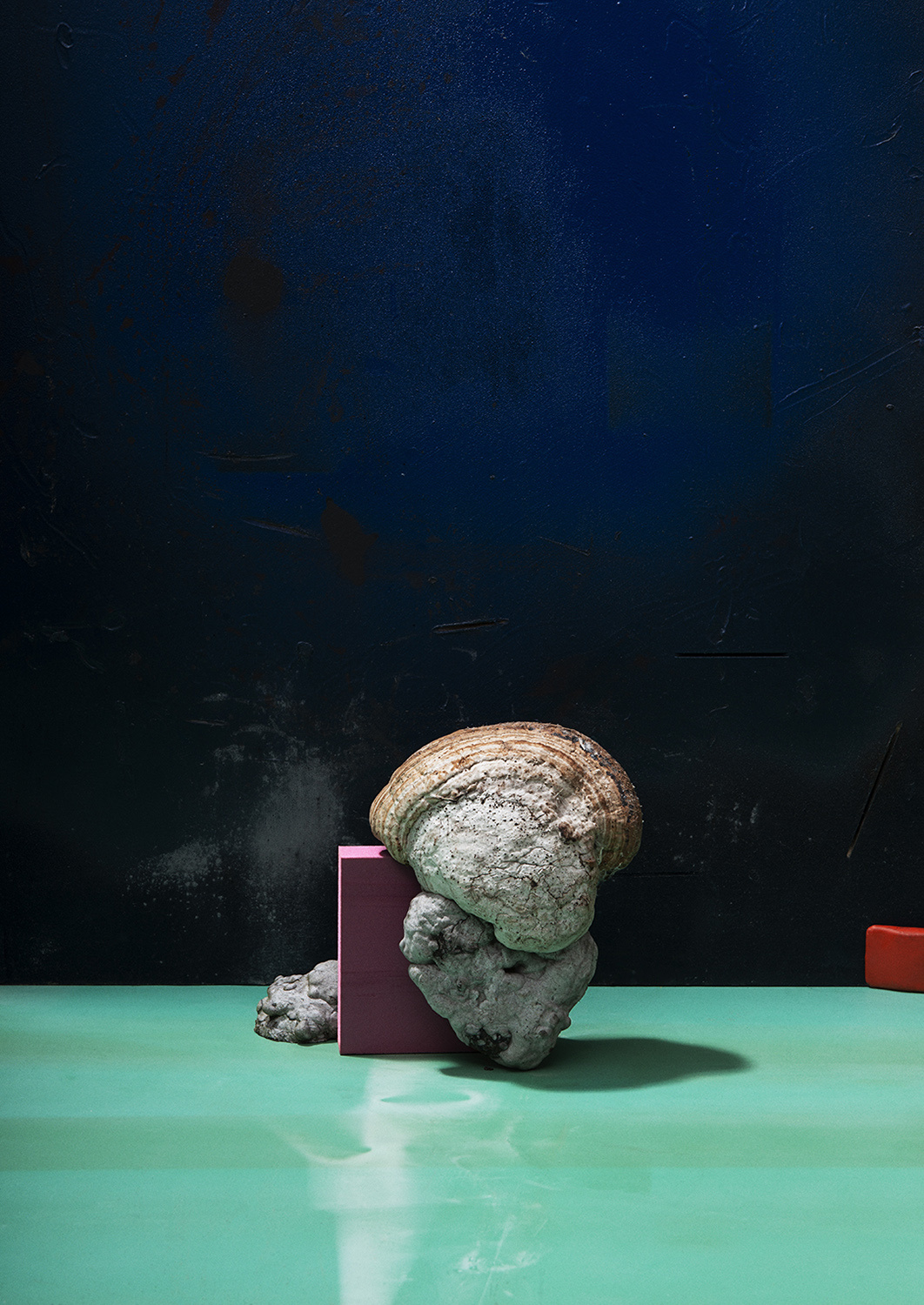 KMA photographer Mattias Nyhlin photographs rocks and a square pink box on a green surface 