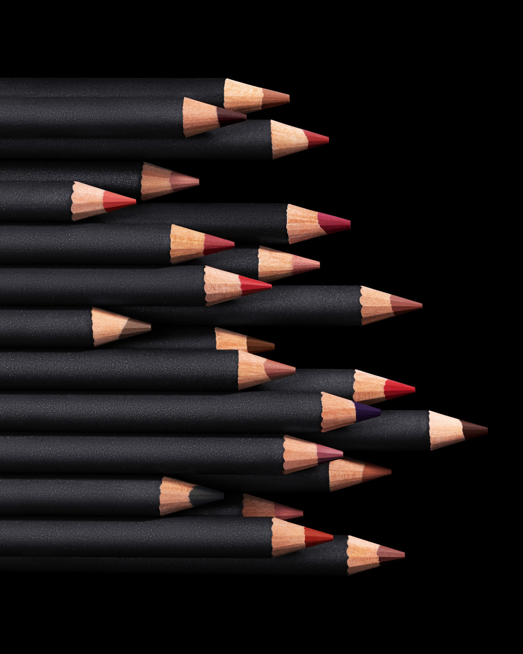 KMA stylist Rachel Haas designs set for photo of many shades of concealer sticks on black background for Hourglass 