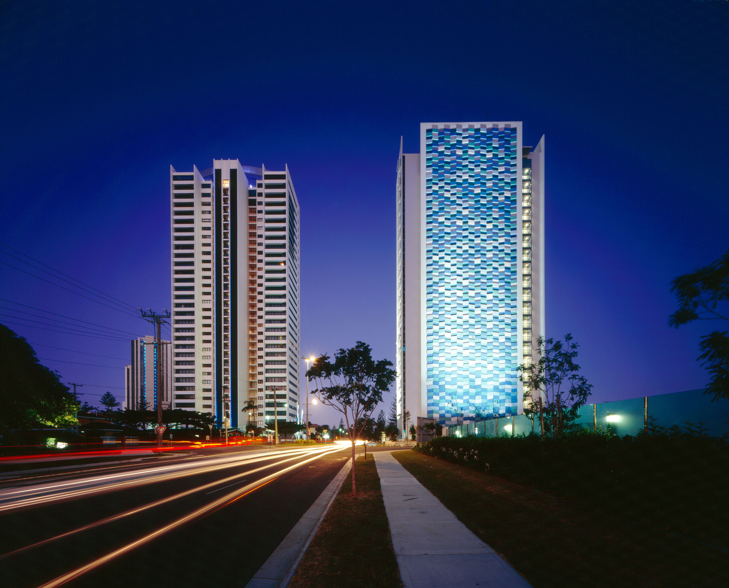 Two towering buildings illuminated by vibrant blue lights, creating a mesmerizing nighttime spectacle.