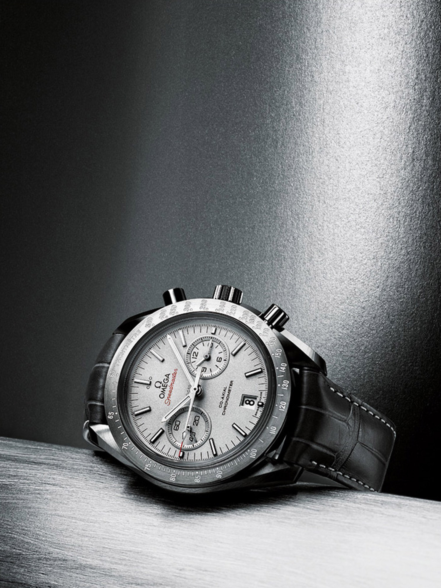 KMA stylist Sara Wacksman designs set for a photo of a silver watch resting on a shiny grey surface 
