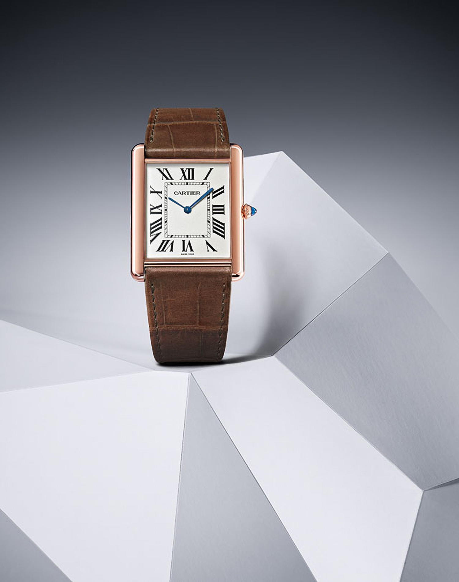 KMA photographer Daniel Schweizer photographs a watch with a brown leather strap on a white and gray surface for Cartier 