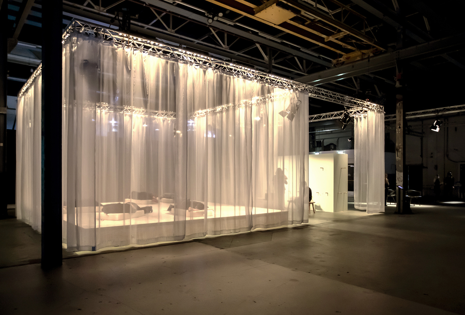 documentation image of the installation from the outside view. the curtains are hanging from a metal structure that surrounds the entire installation.