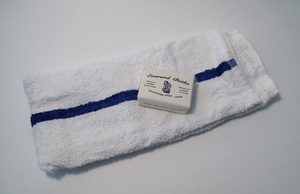 Everard Baths soap sits on top of a white towel with blue stripe
