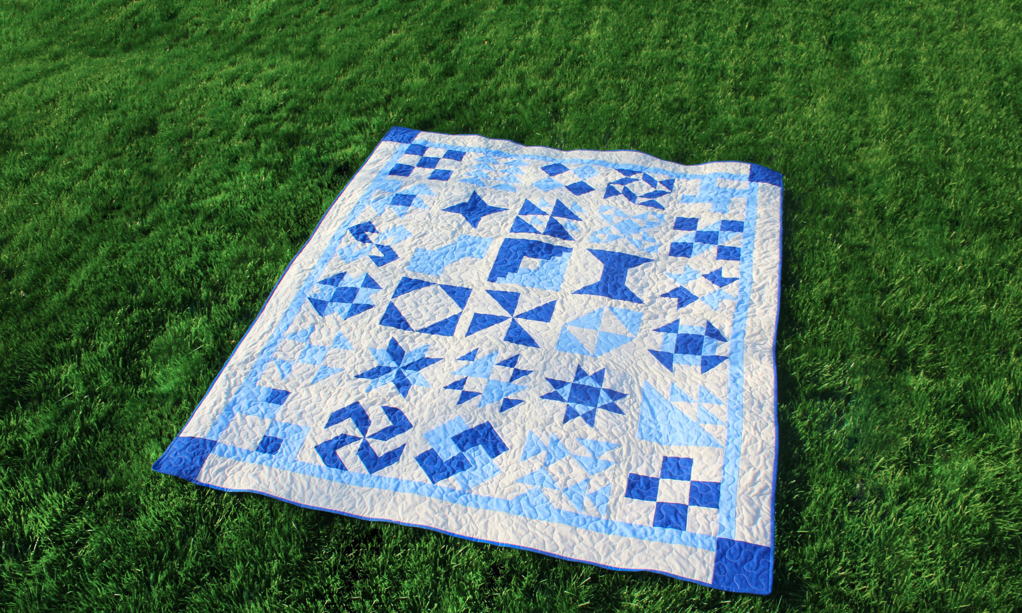 blue and white quilt on grass