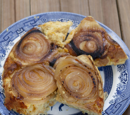 an up-close picture of sweet onion upside-down cornbread on a blue willow plate