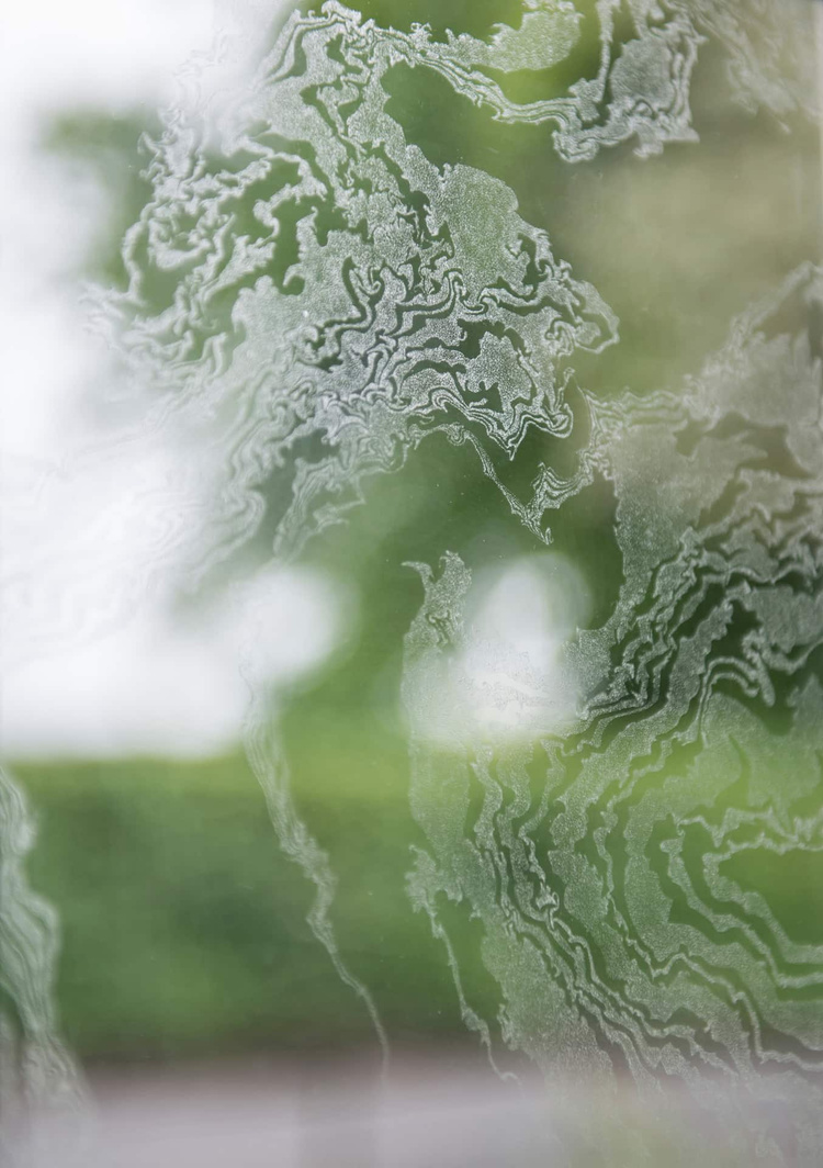 Detail of the Window, showing the meticulous glass engraving that translates the Suminagashi marbling with thousands of tiny impressions.